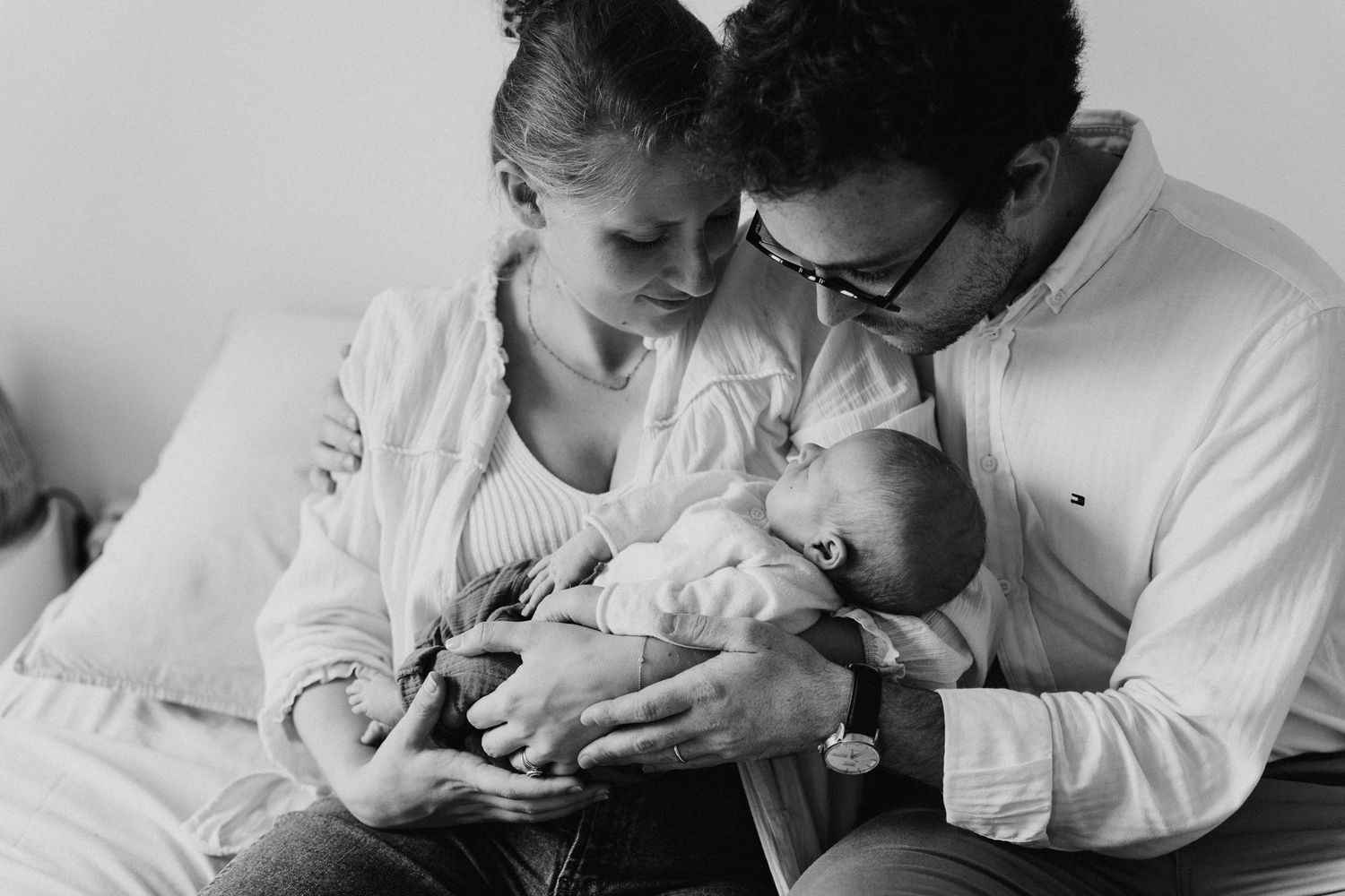 Parents tendres avec leur nouveau-né sur un lit, noir et blanc