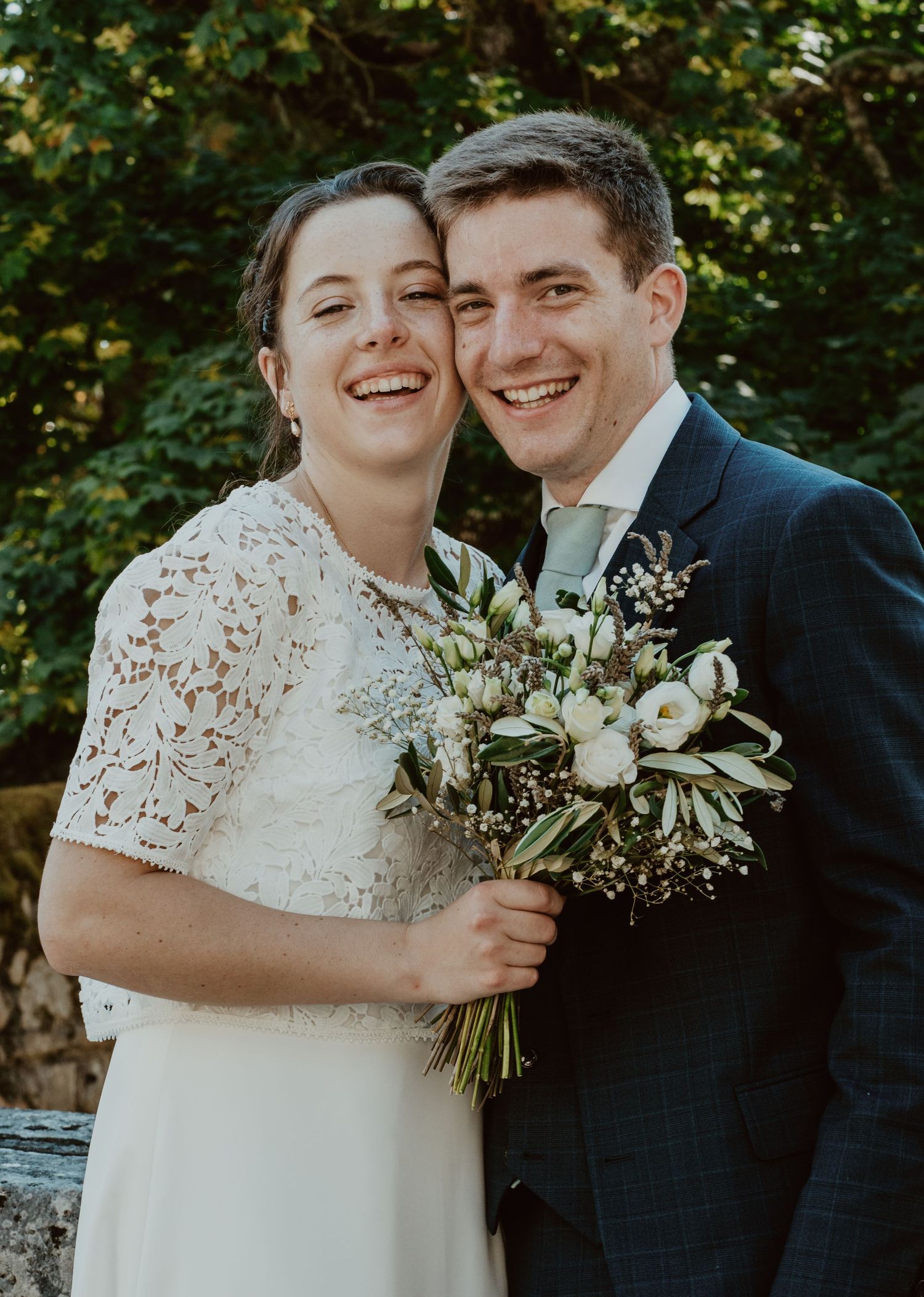 Mariés souriants, mariée en dentelle avec bouquet