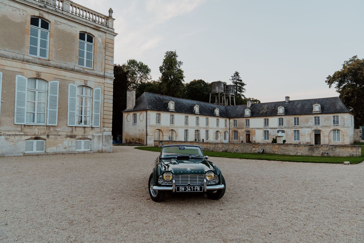 Château de mariage avec voiture d'époque garée devant la façade, décor du discours