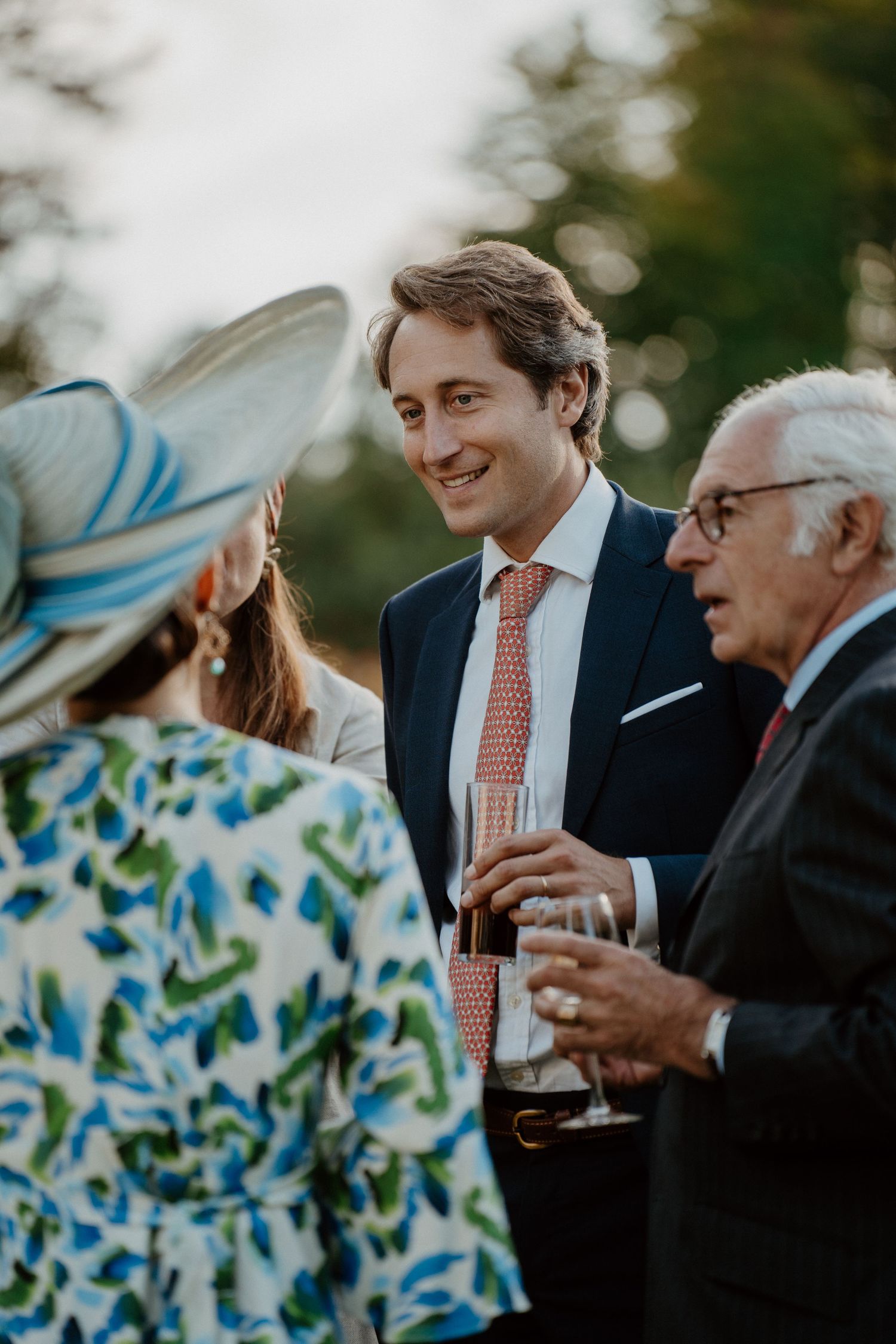 Invité en pleine conversation, chapeau et coupe de champagne à proximité
