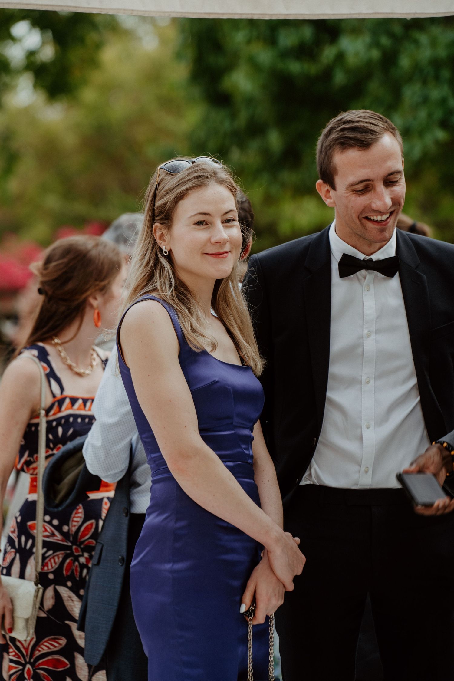 Couple d'invités souriants pendant le cocktail en extérieur