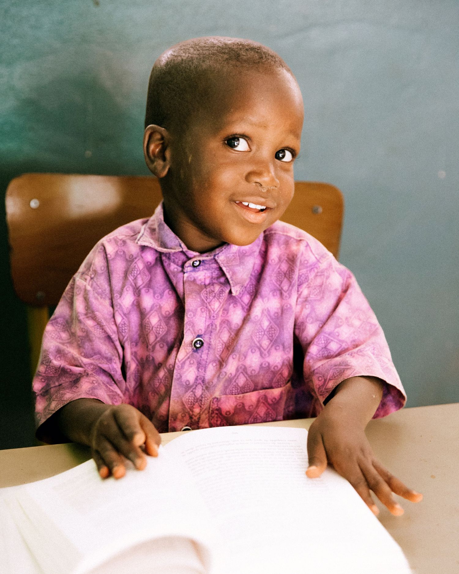 Portrait d'un enfant souriant à son pupitre
