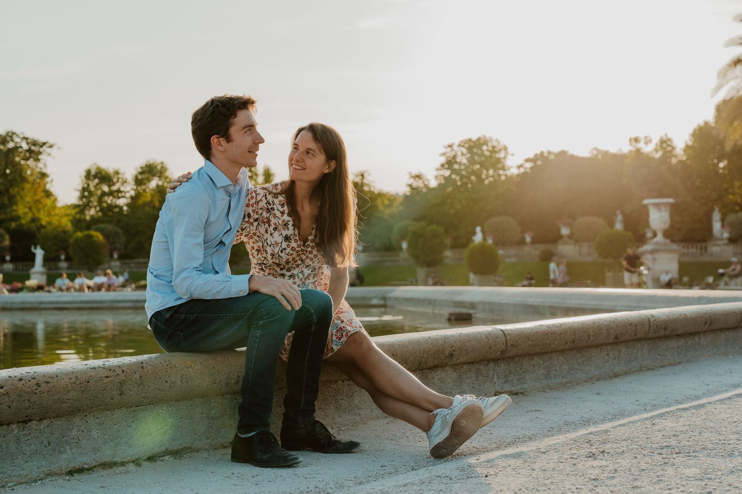 Couple assis au bord d'une fontaine au coucher du soleil jardin du Luxembourg