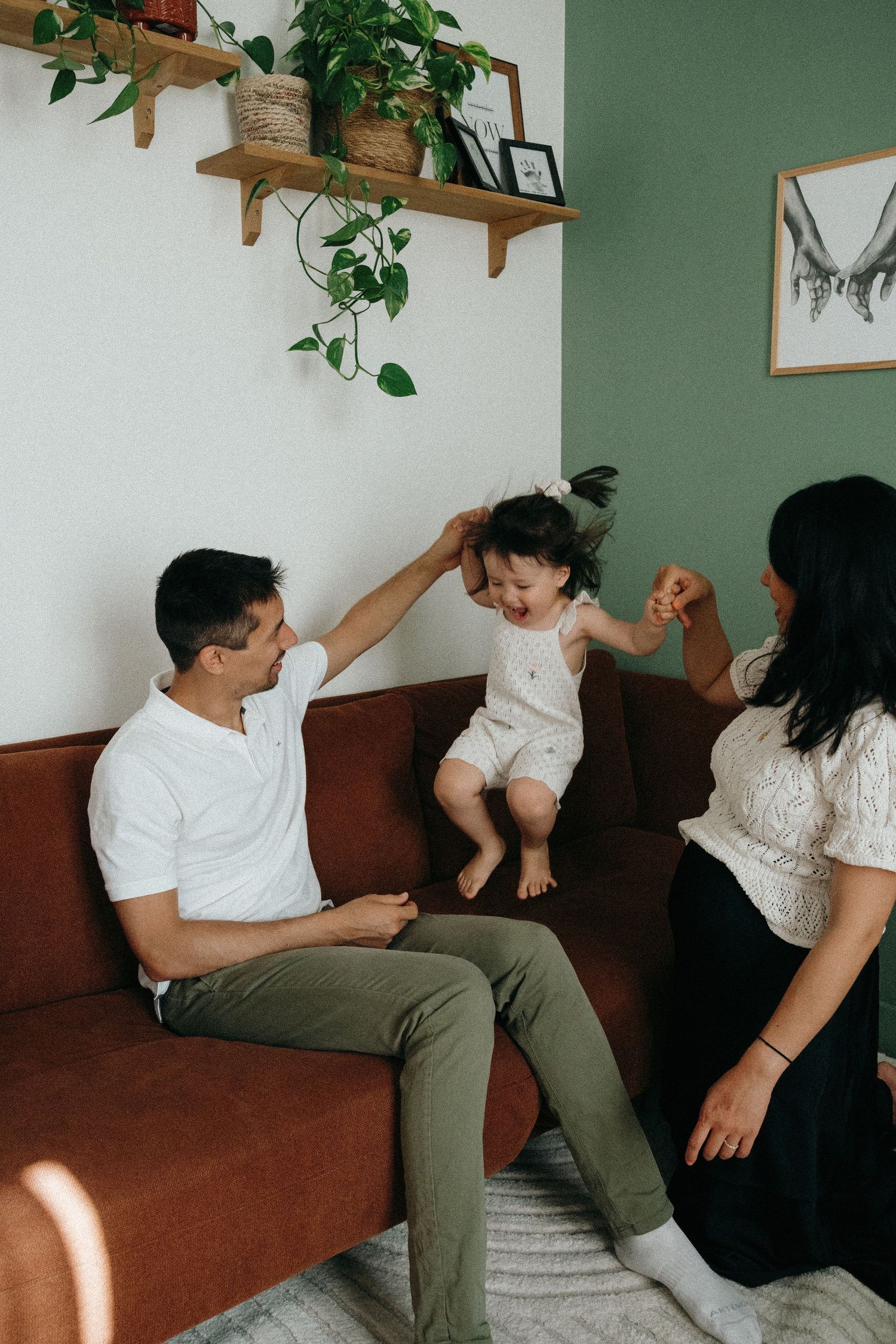Famille joyeuse jouant avec son enfant sur un canapé