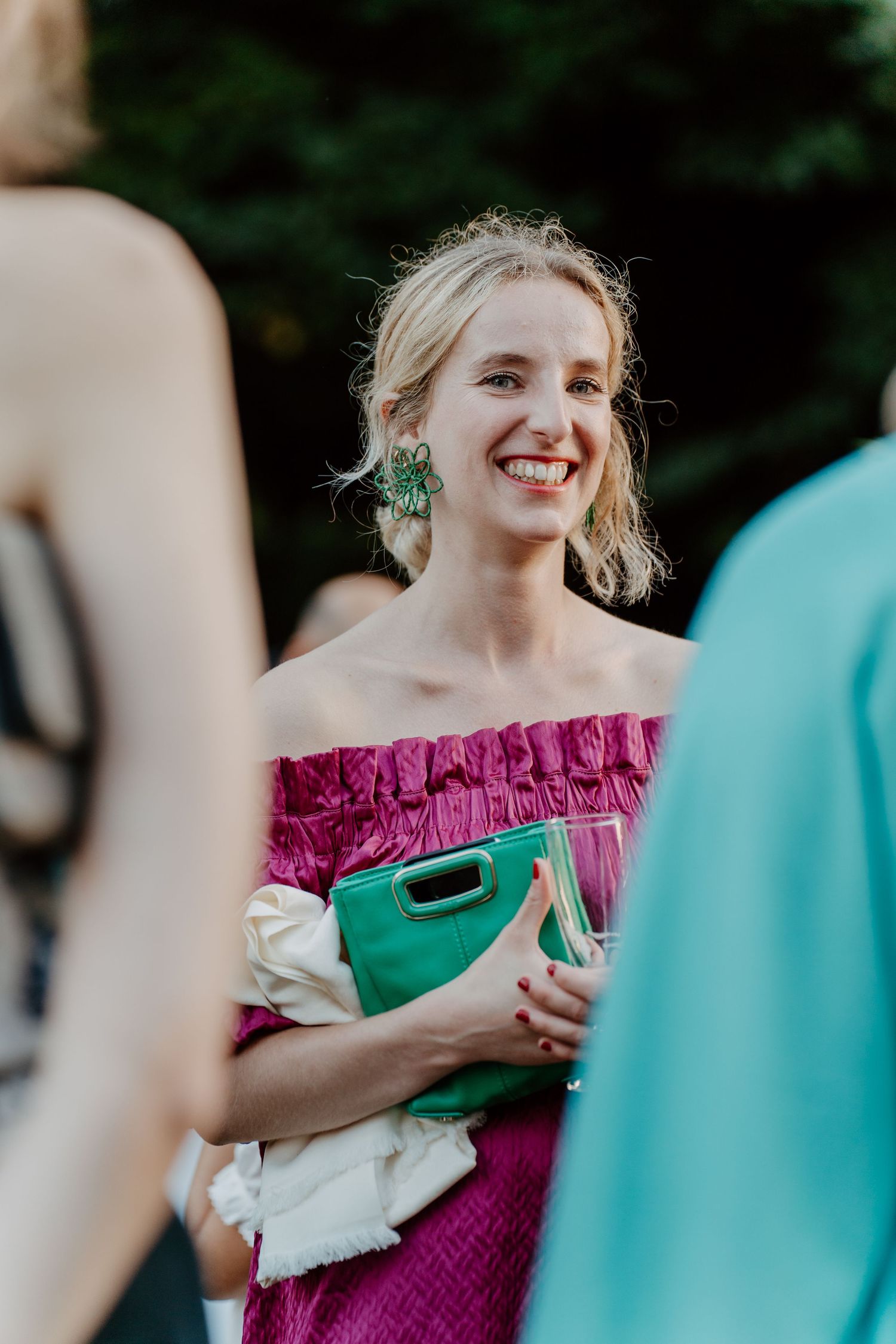 Invitée en robe rose fuchsia souriante pendant le cocktail de mariage