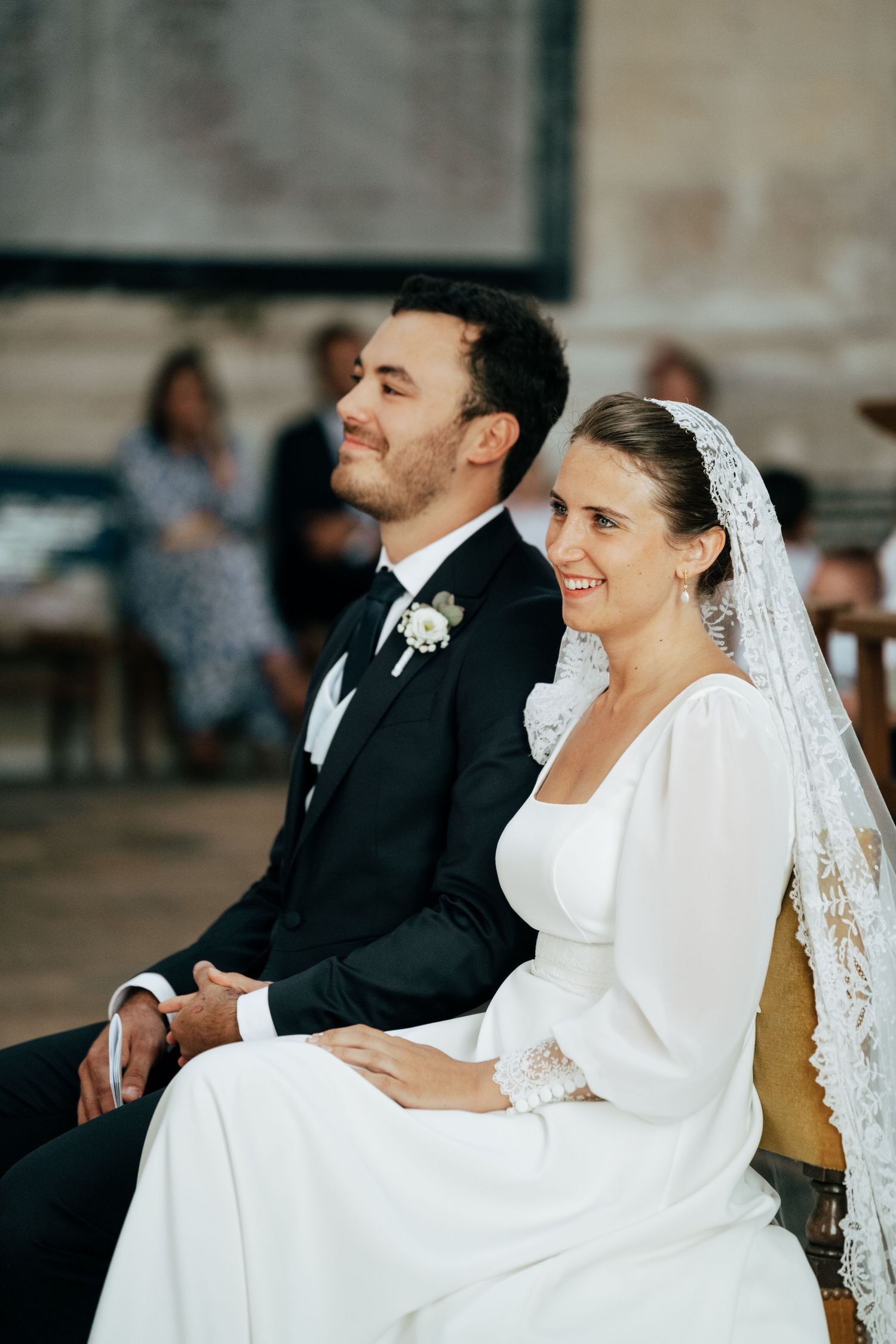Les mariés assis à l'église pendant la messe de mariage