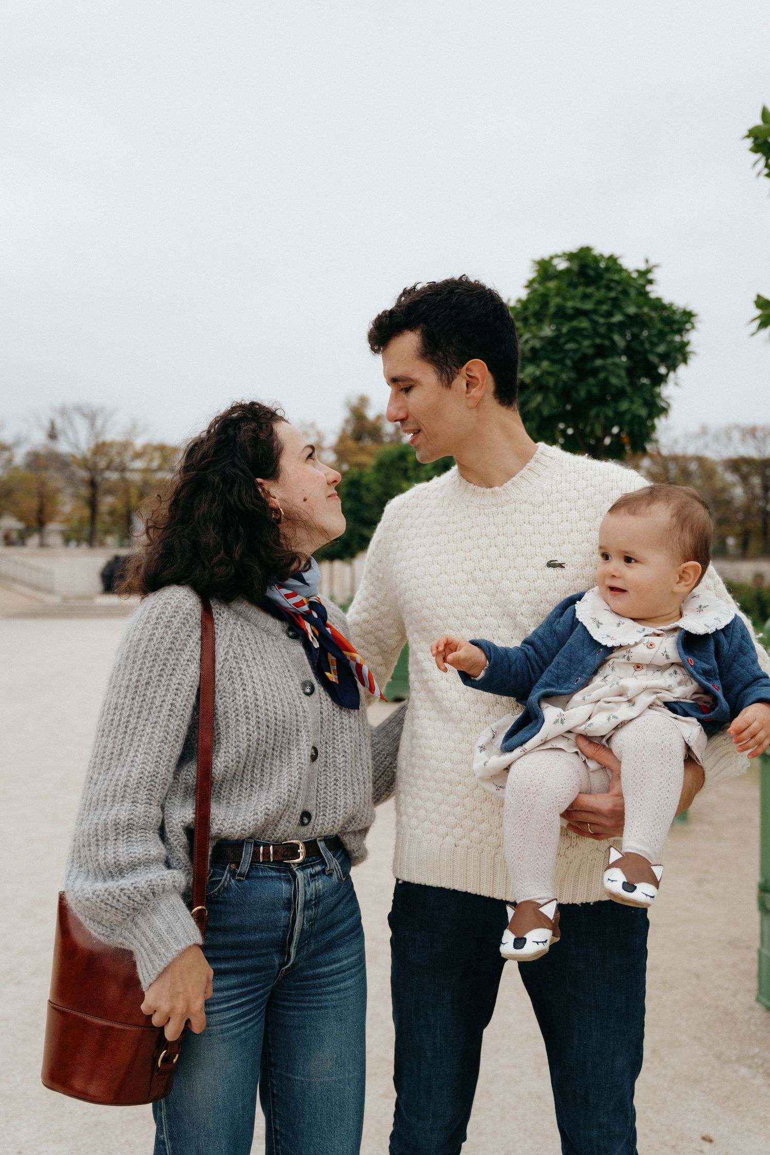 Jeune famille en balade avec leur petite fille dans un parc