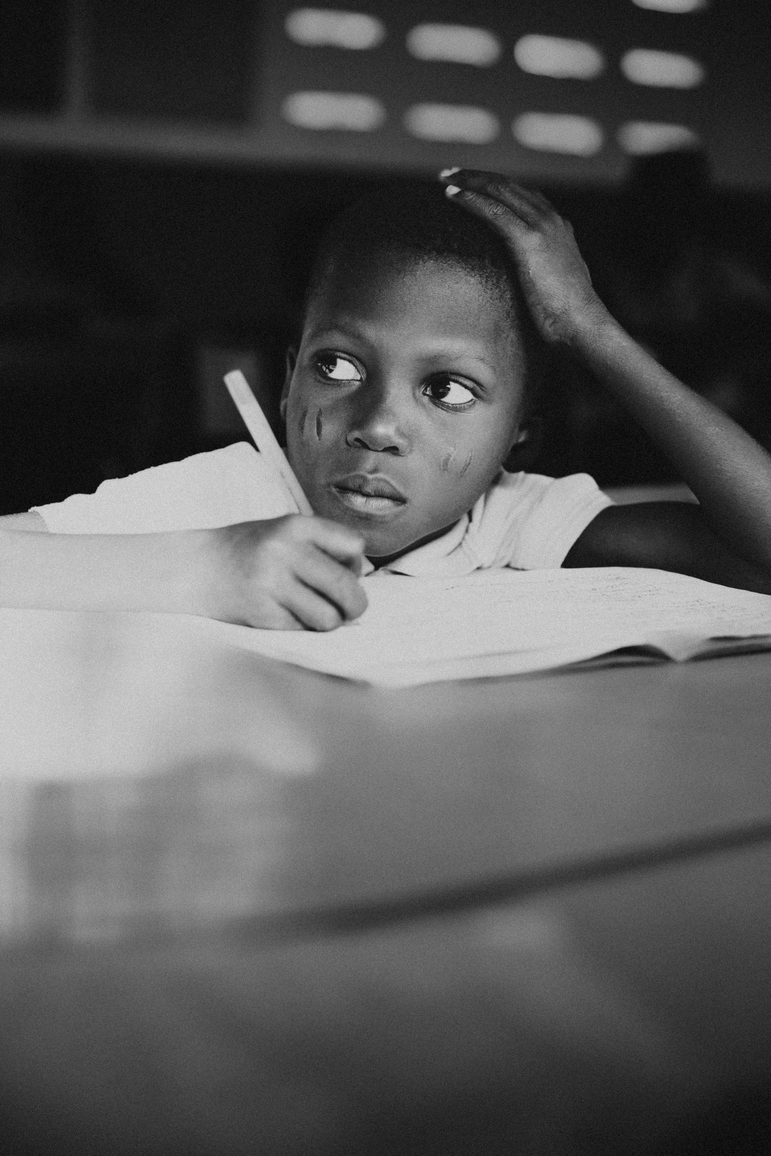 Portrait noir et blanc d'un enfant en train d'écrire