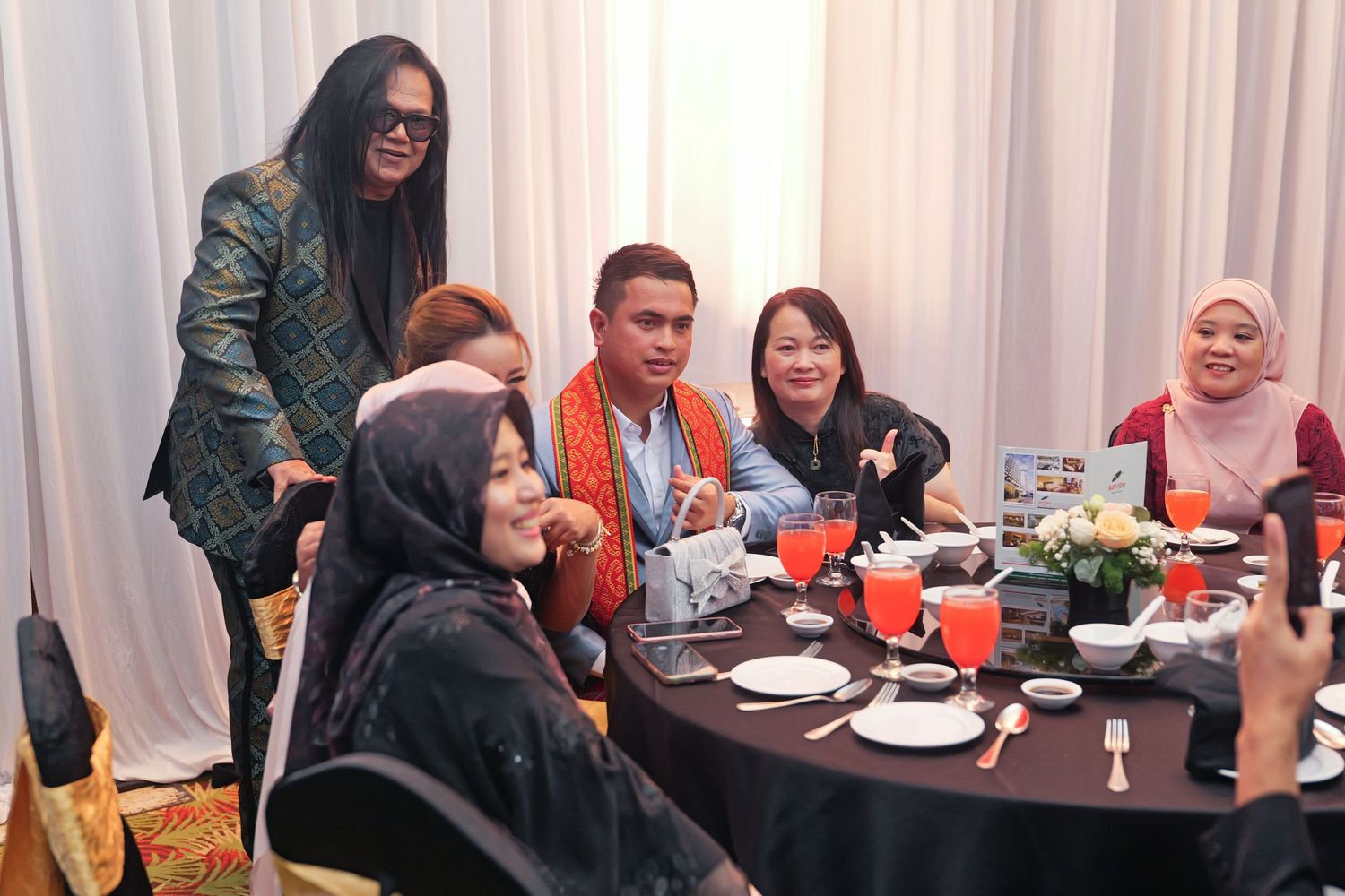Group of colleagues socializing and dining together at a formal corporate dinner event.