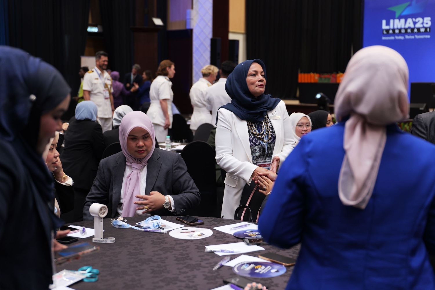 Conference attendees engaging in group discussion at a networking event.