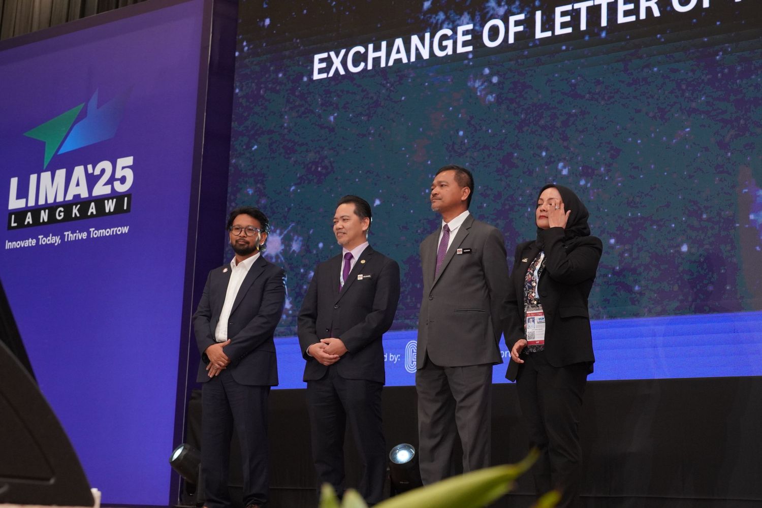 Conference stage setup with 'LIMA25' branding displayed on digital screens.