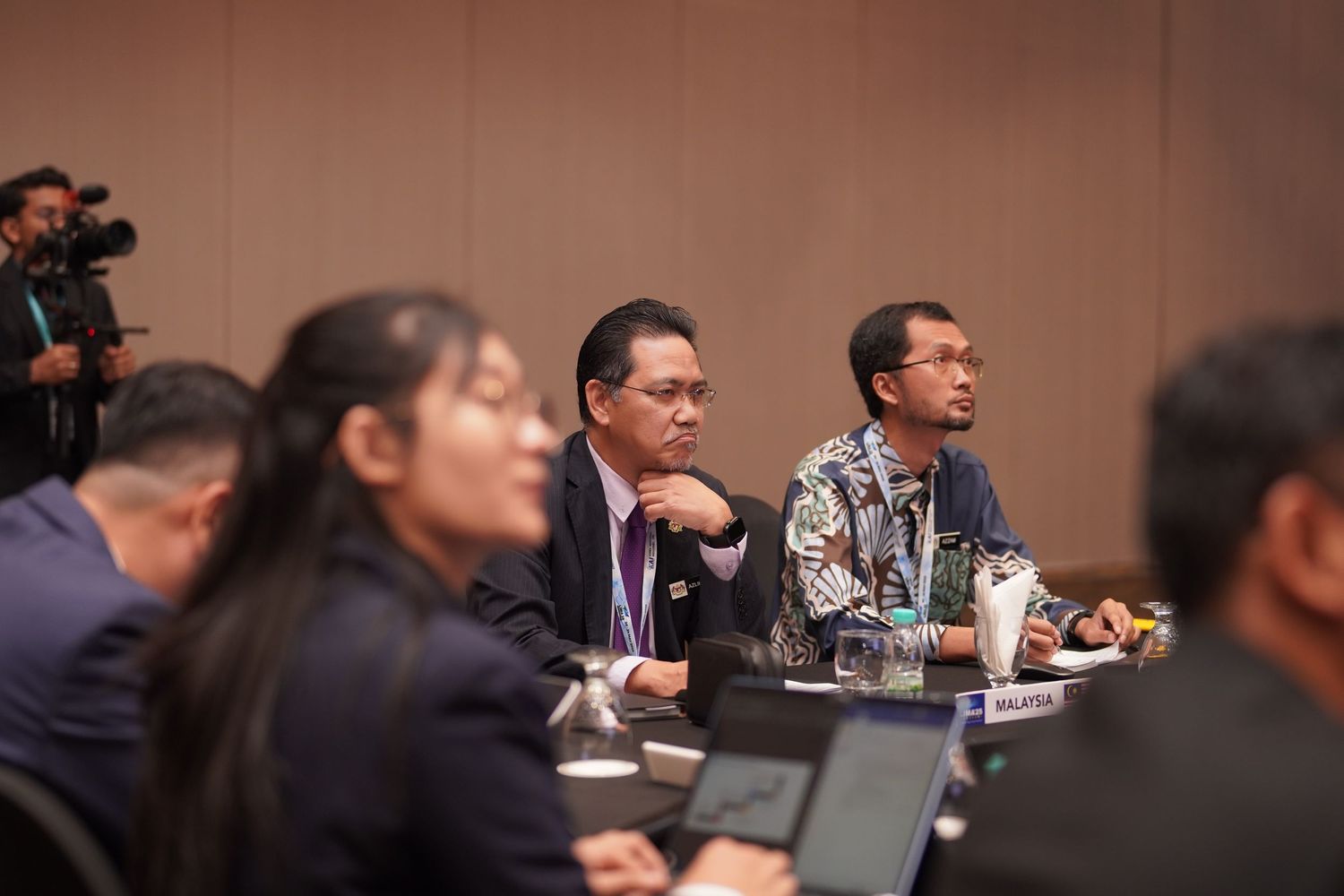 Conference participants engage in discussion during roundtable meeting session.