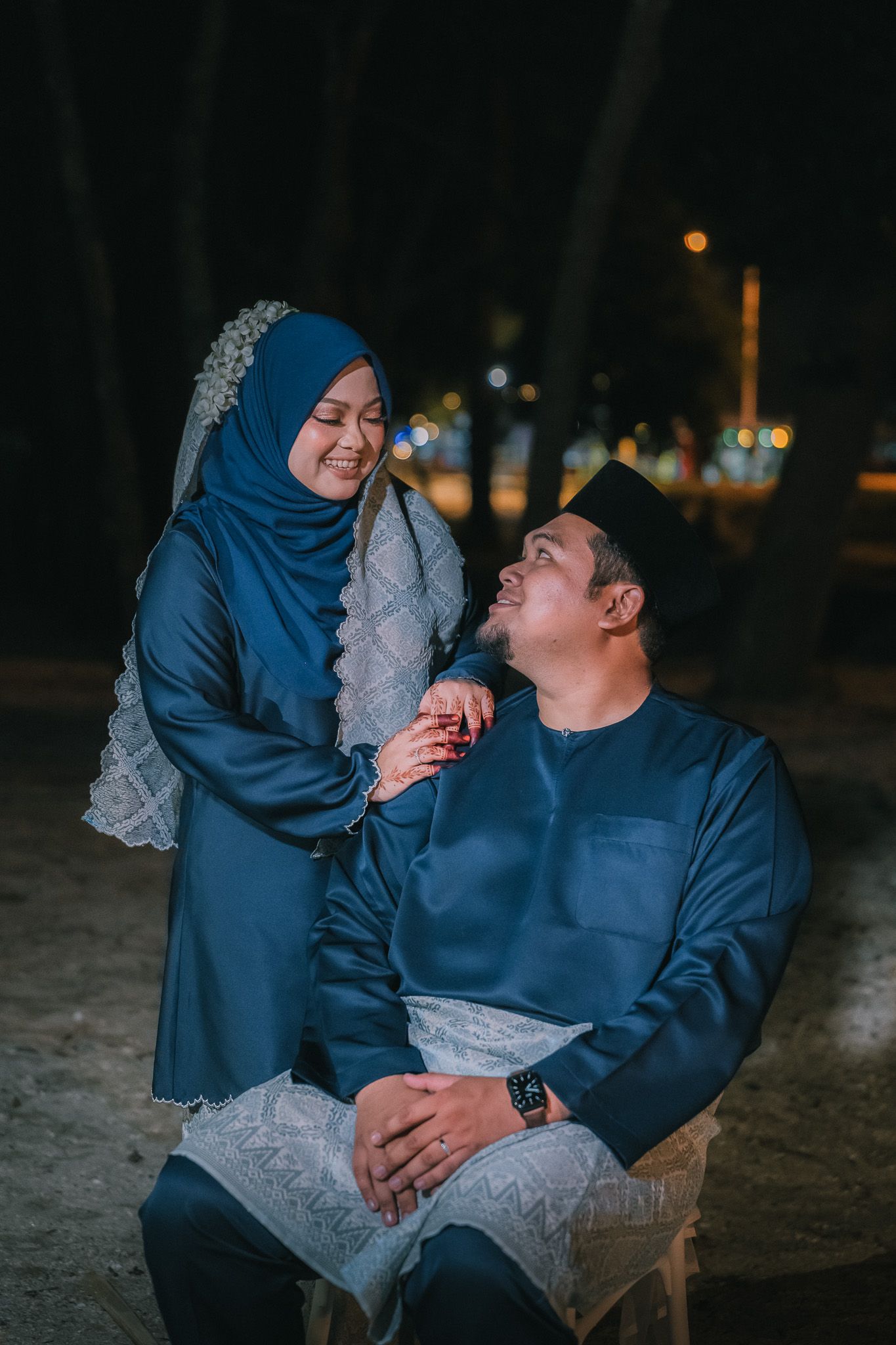 Romantic couple sharing intimate moments on a dimly lit evening outdoors.