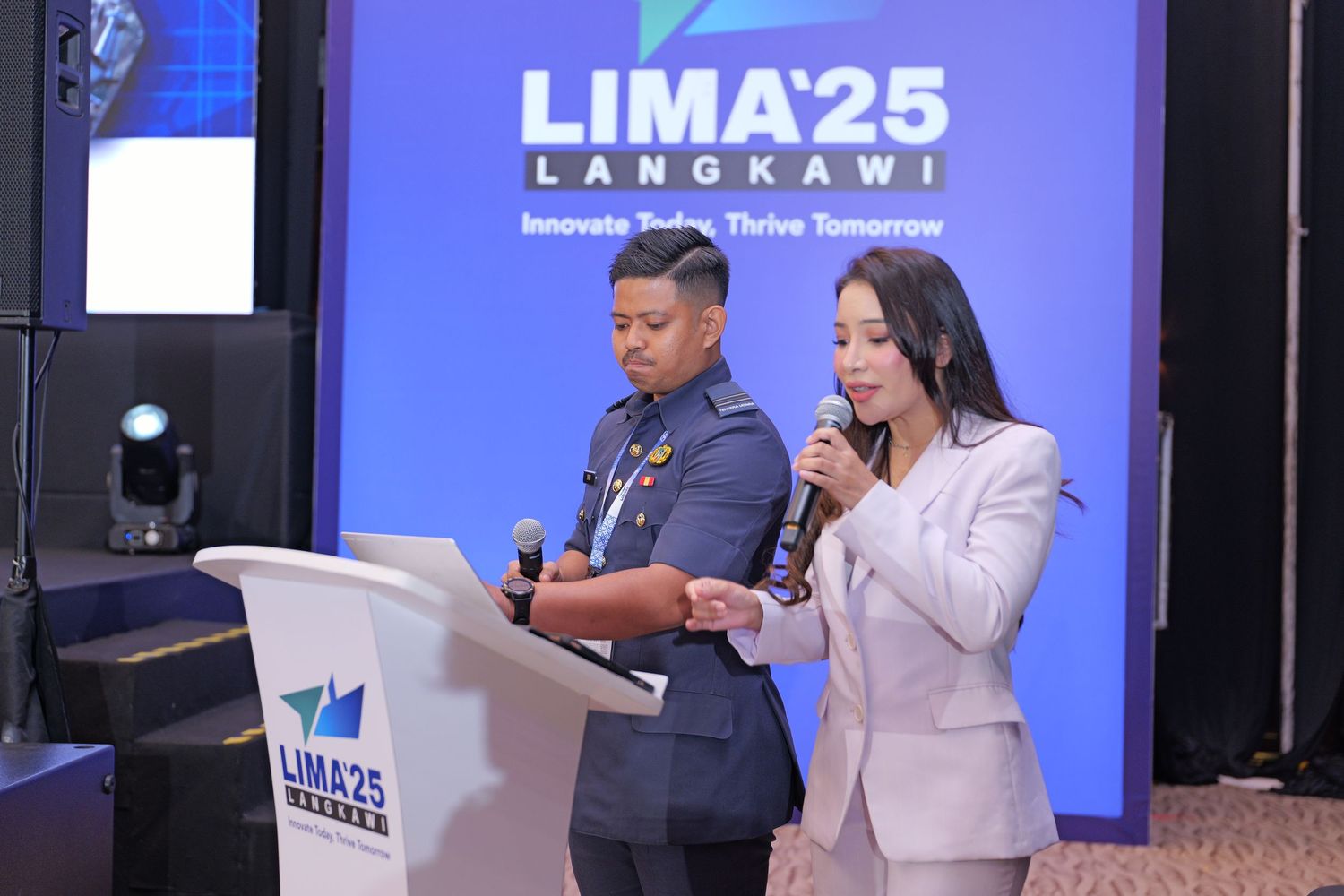 Two speakers presenting on stage at LIMA25 Langkawi aviation conference.