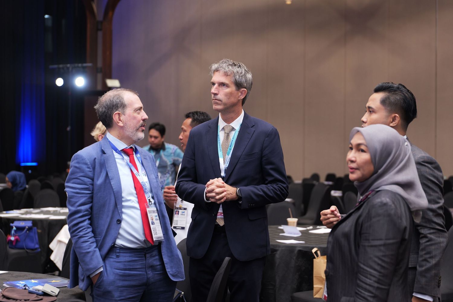 Group of conference attendees engaged in networking discussion at a professional event.