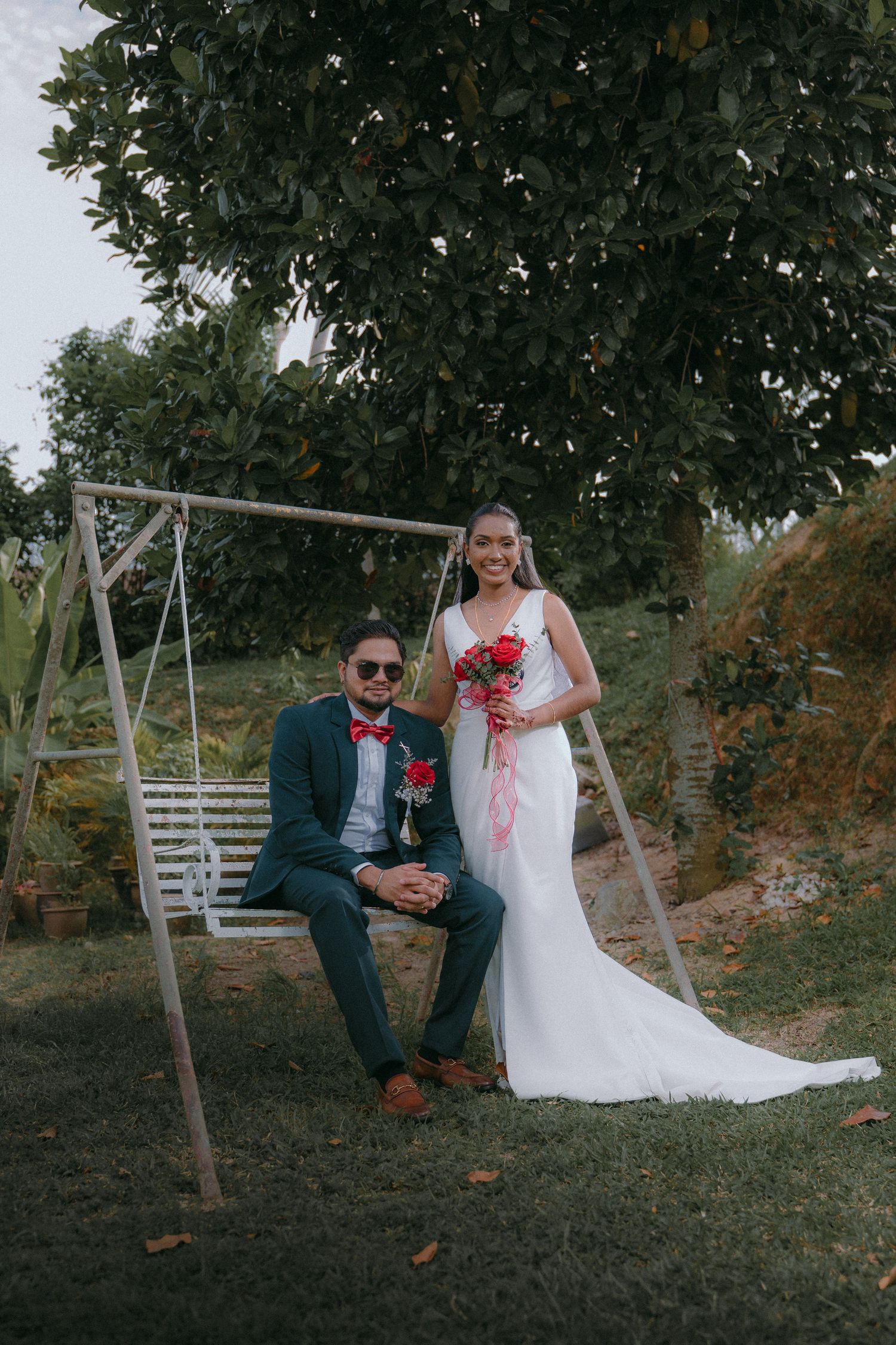 Romantic Halloween-themed wedding portraits with a bride and groom posing near a wooden swing set at sunset.