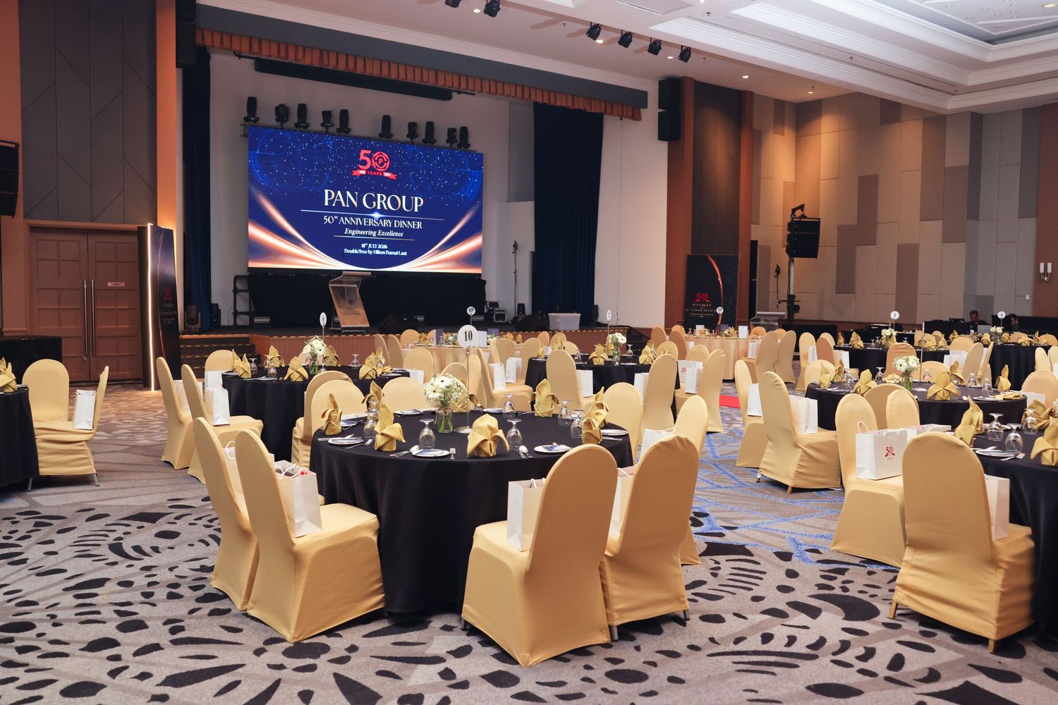 Elegant banquet hall setup with gold and black chairs for Pan Group corporate dinner event.