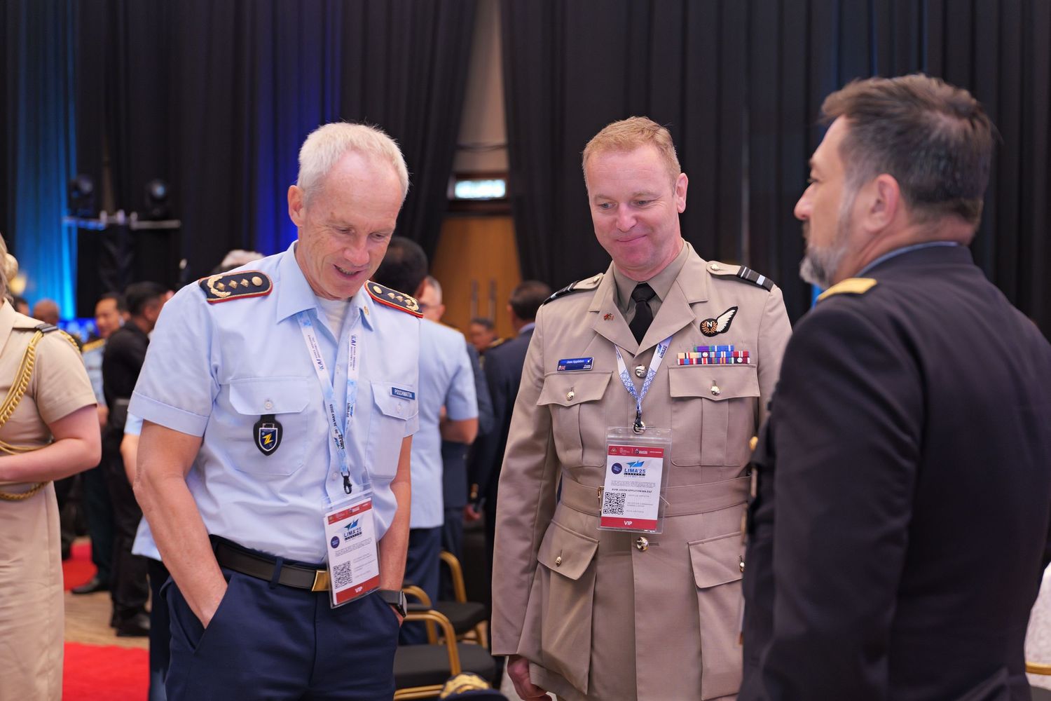 A group of uniformed personnel conversing during what appears to be a conference or professional event.
