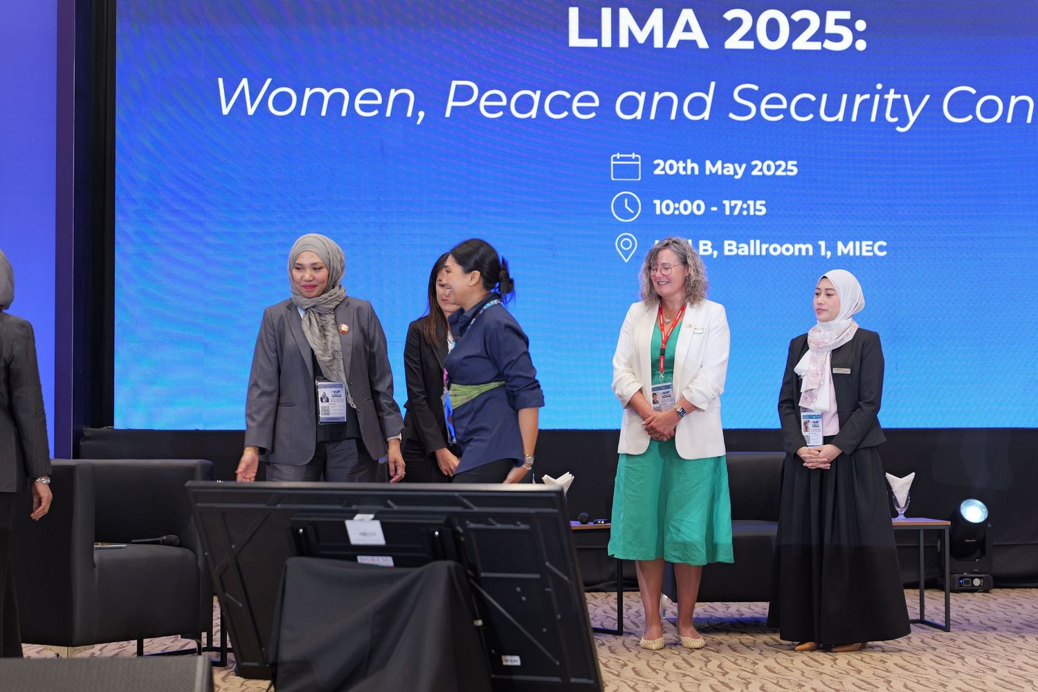 Panel speakers presenting at the Lima 2025 Women, Peace and Security conference on stage.
