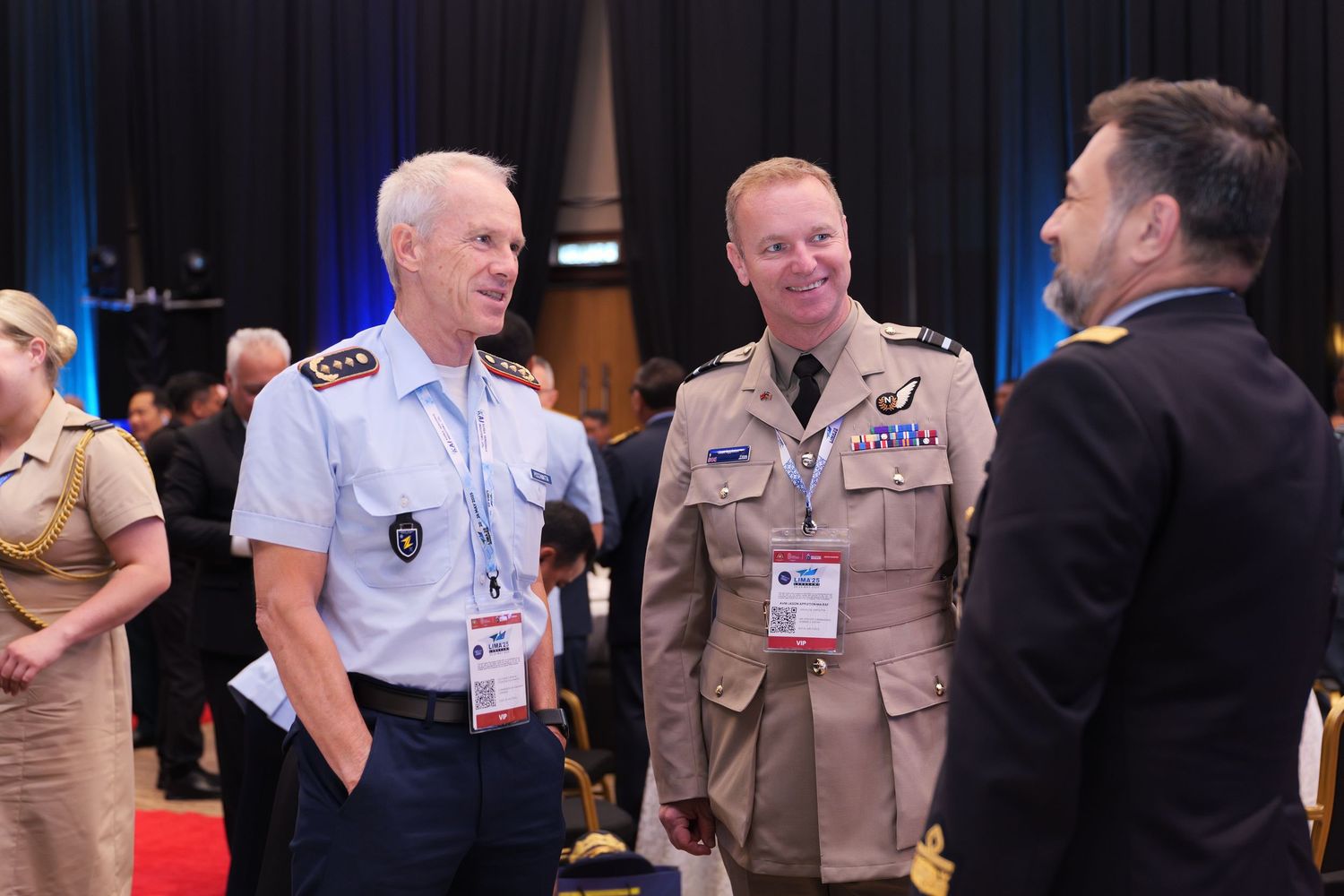 Military officers in dress uniforms engaging in conversation at a formal gathering.