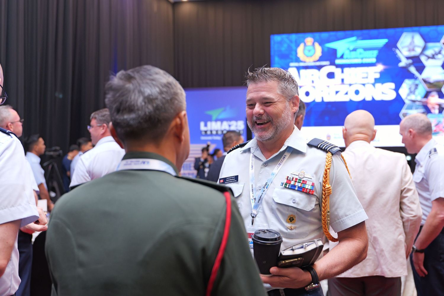 Military officers engaged in conversation at a professional conference event.