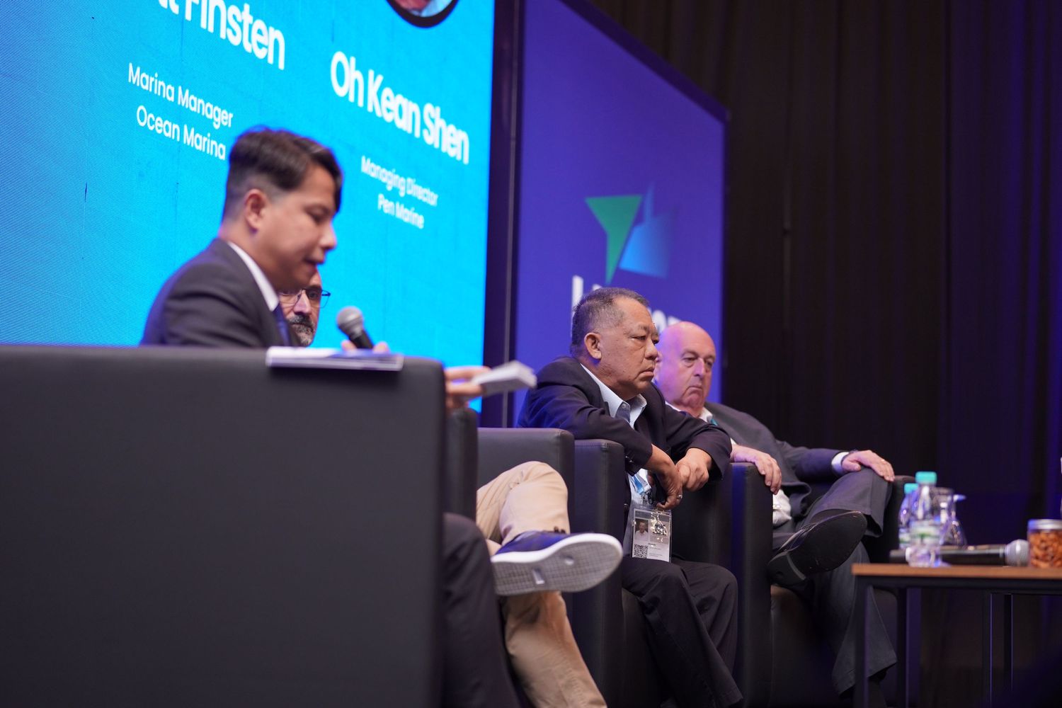 Panel discussion with speakers seated on stage at professional conference.