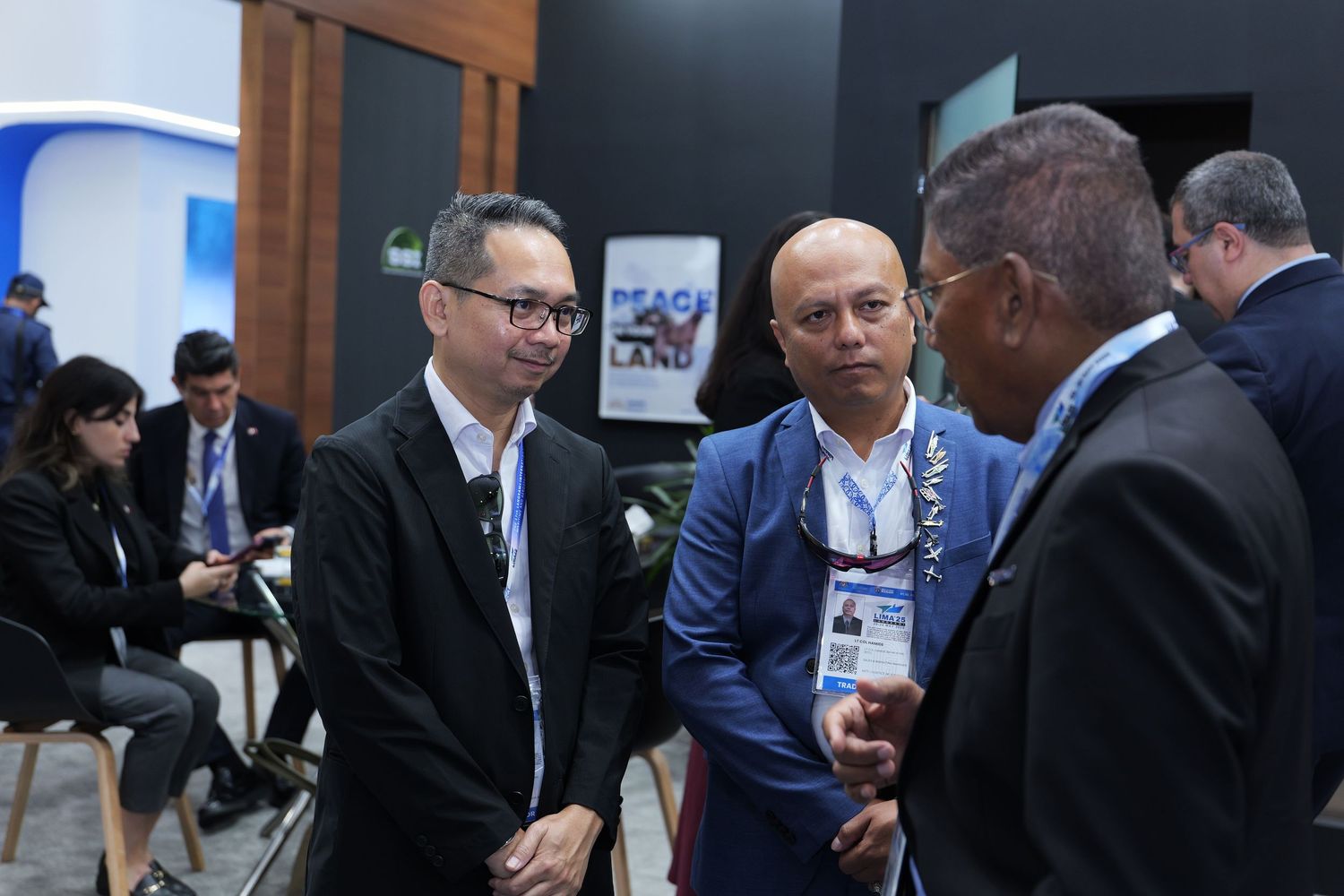 Business professionals engaged in discussion at a technology conference or corporate event.