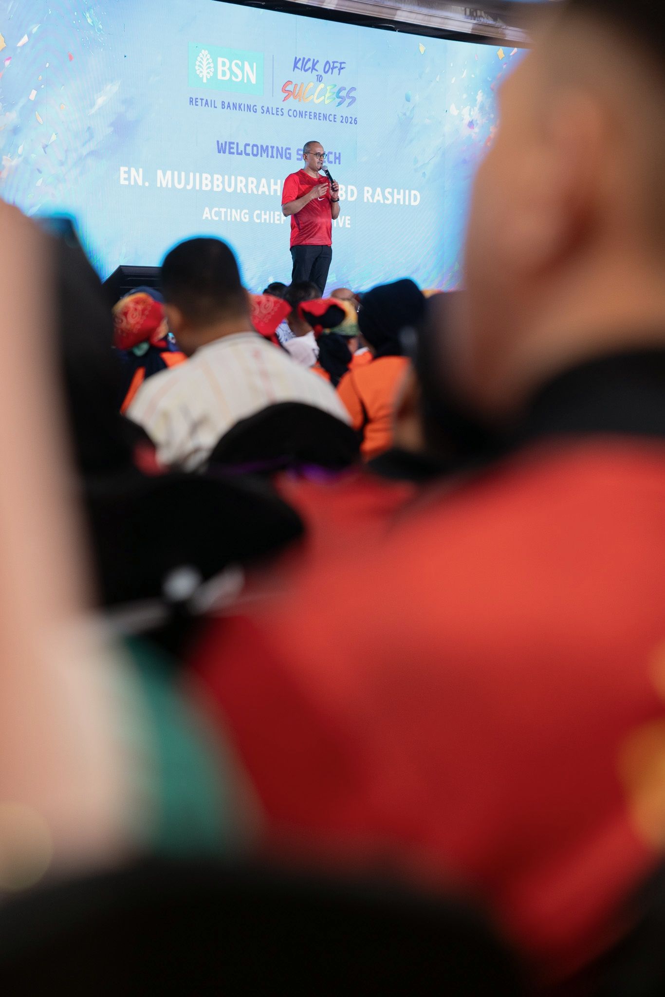 Speaker addresses crowd at BSN Retail Banking Sales Conference Kick Off Success event on stage.