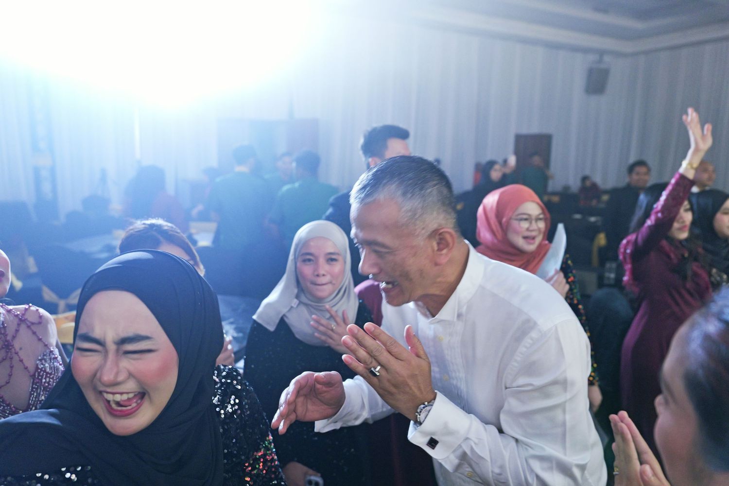 People laughing and celebrating together at an indoor social gathering event.