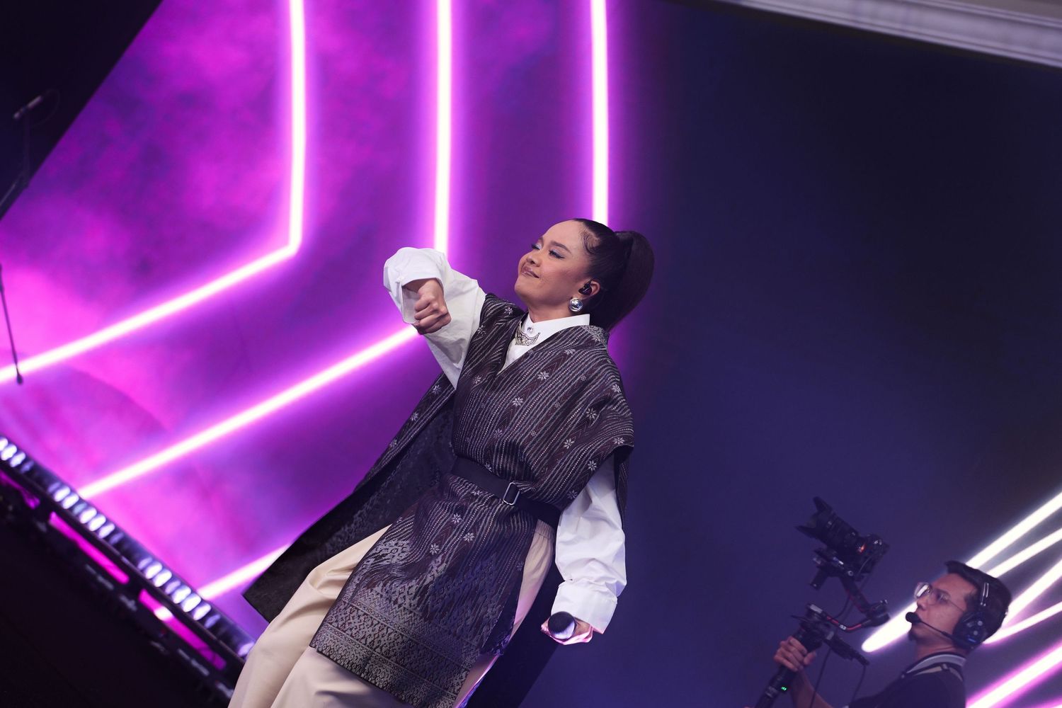 Female performer on stage with purple neon lights at corporate gala dinner event.