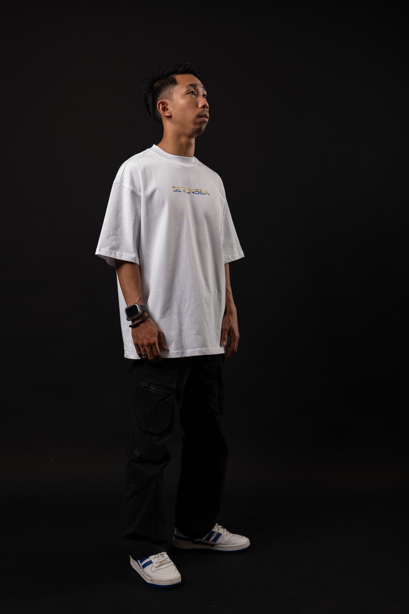 Four views of a person wearing a white t-shirt and black pants posing against a dark background.
