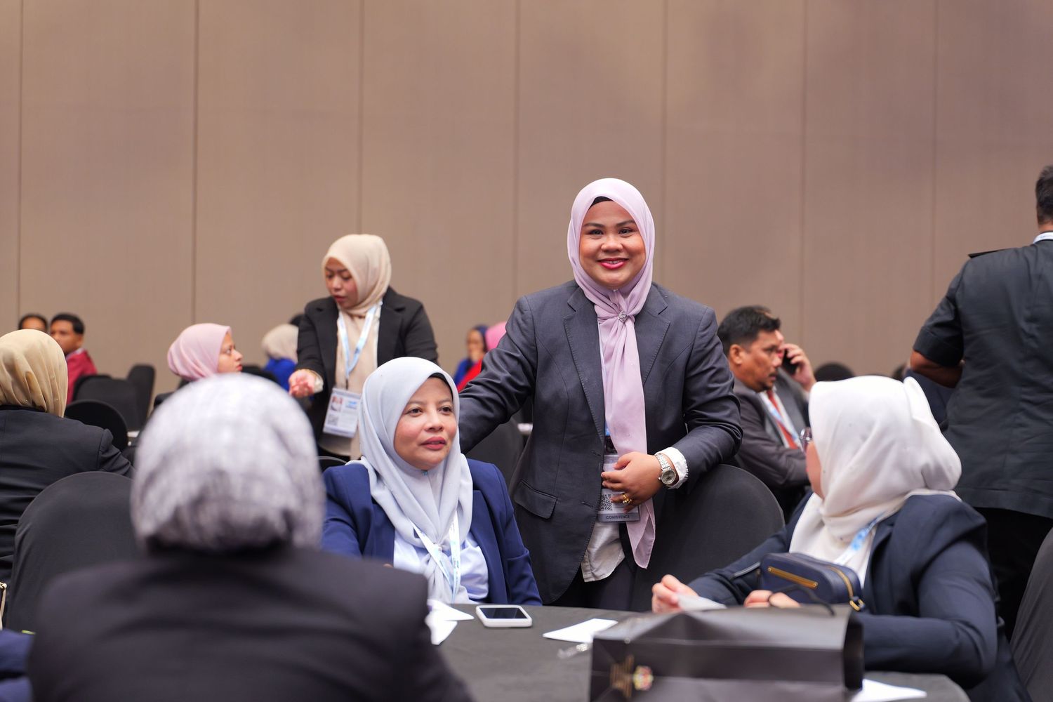 Conference attendees engaged in discussion and networking during a professional business event.