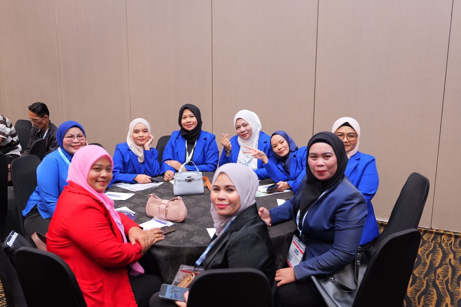 Diverse group of professionals collaborating around a table at a business conference.