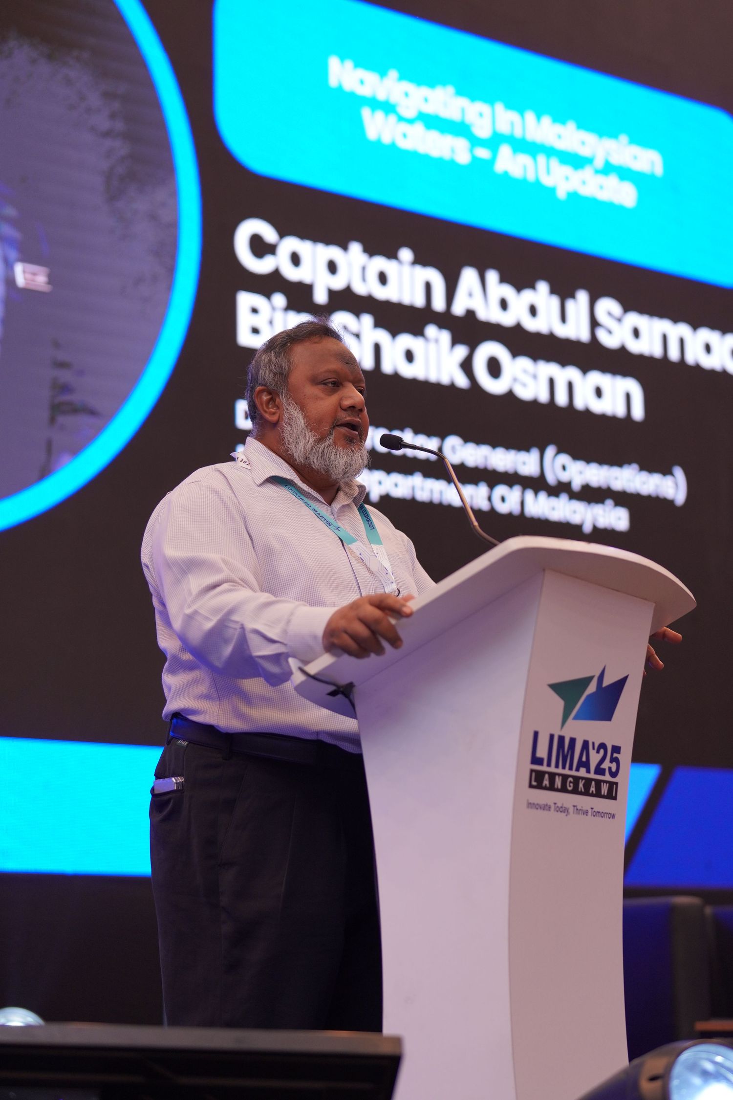 Speakers presenting at white podiums against a bright blue digital display backdrop.