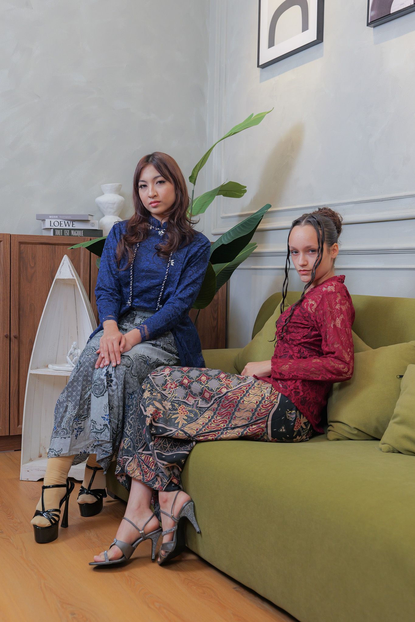 People sitting casually on a lime green couch in a modern living room with hardwood floors and white walls.