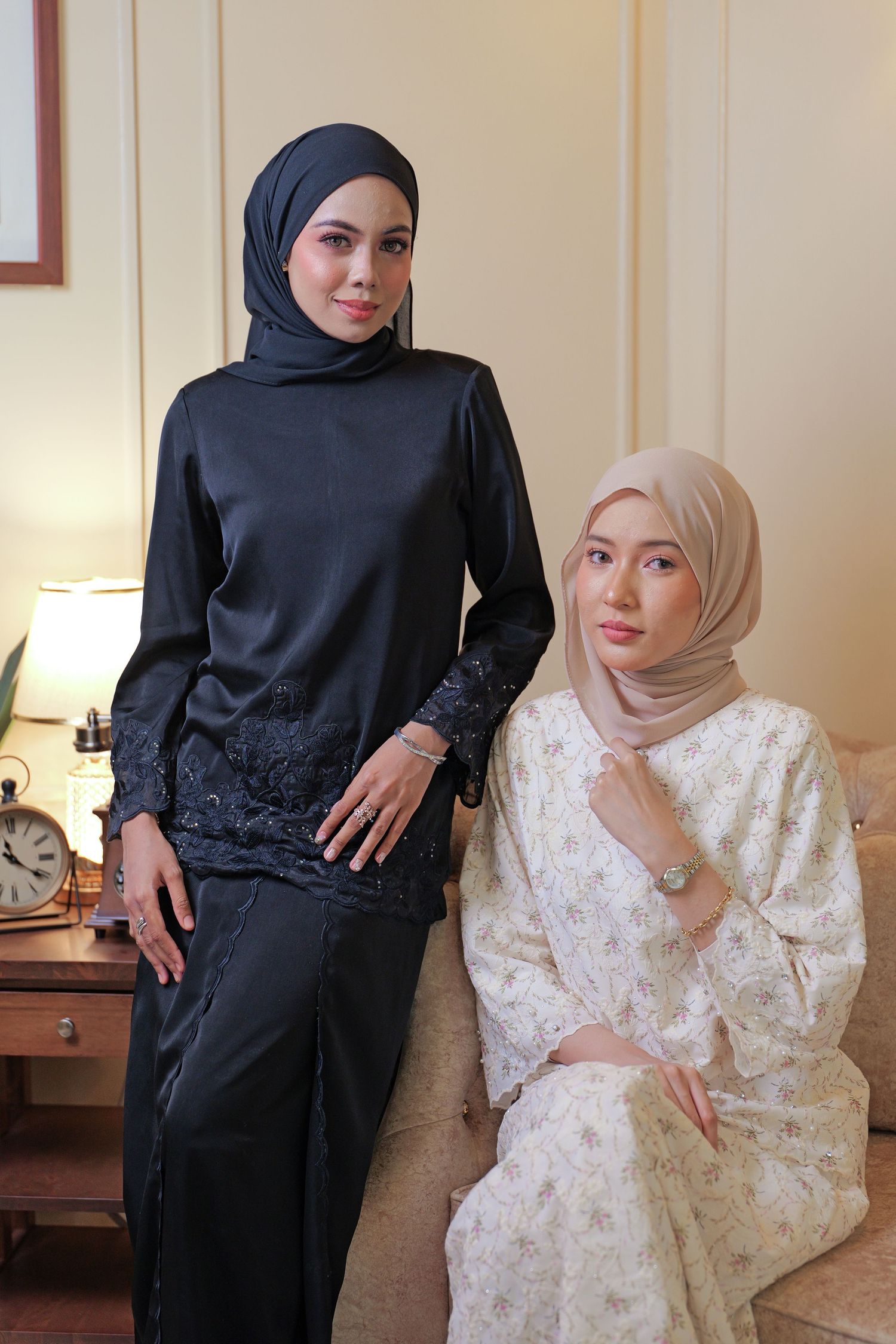 Two people pose in contrasting black and white traditional Muslim dress showing different styles and details.