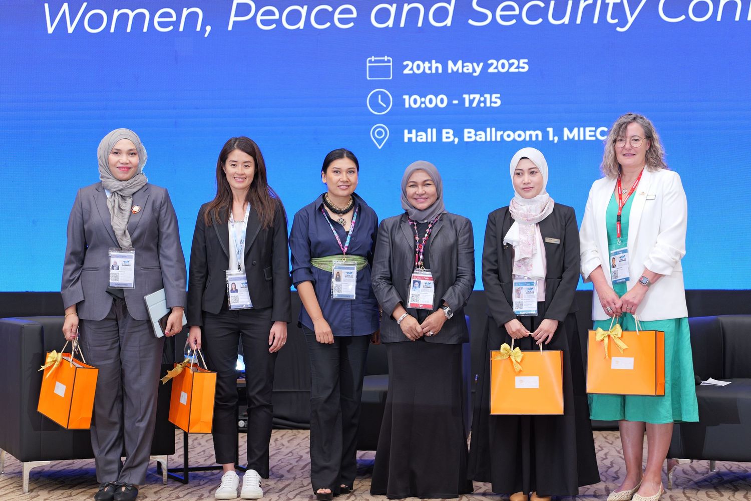 Group of conference participants with gift bags posing at Women, Peace and Security Conference.