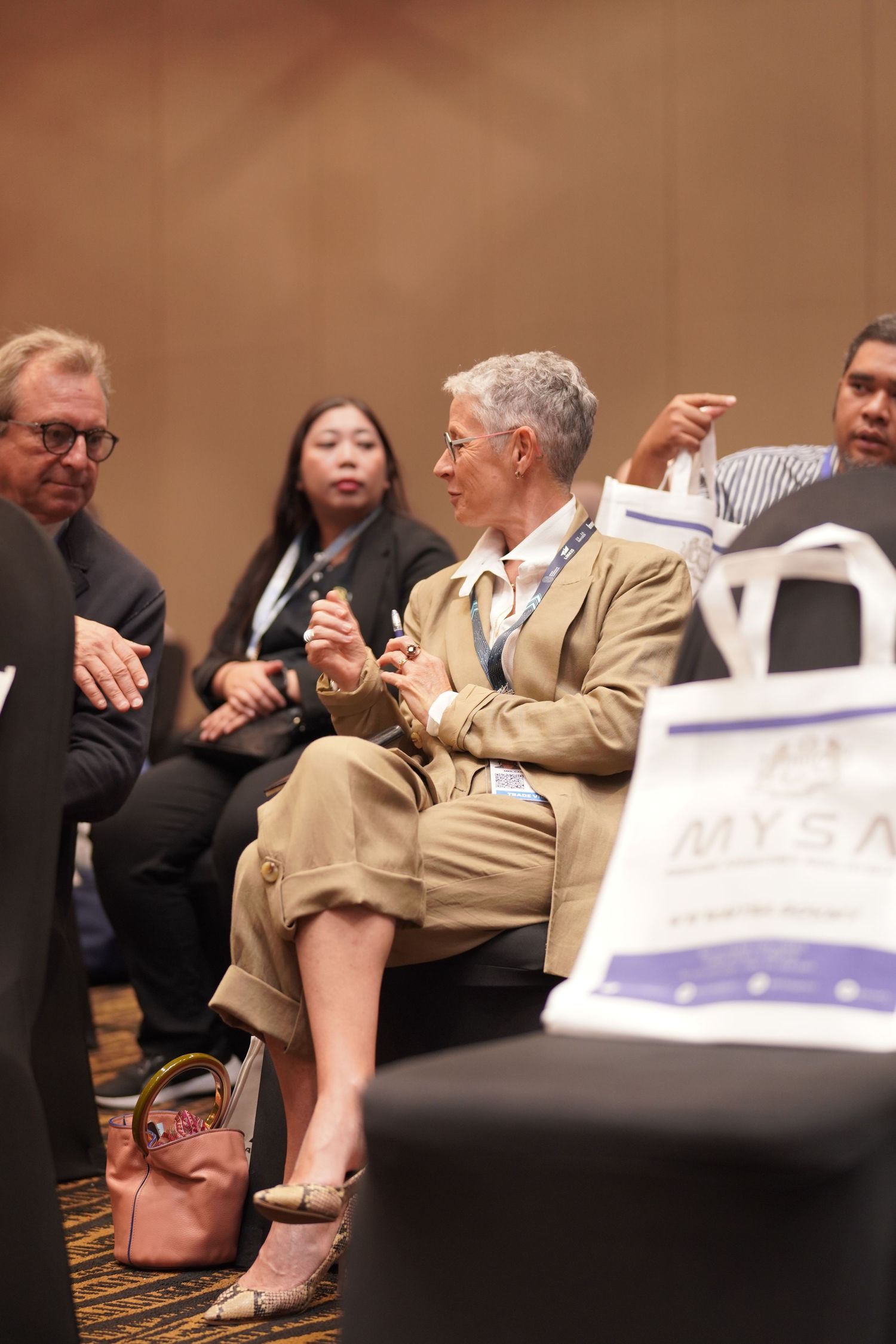 Several people engaged in animated conversation while seated at what appears to be a conference or meeting event.