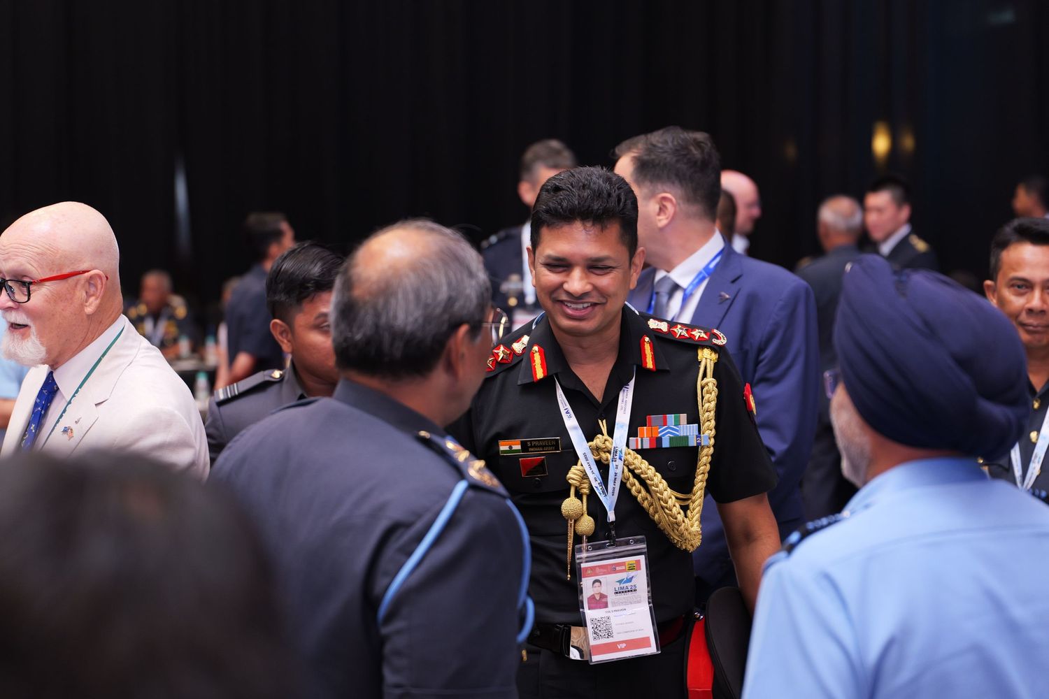 Military officers in dress uniforms networking during conference break.