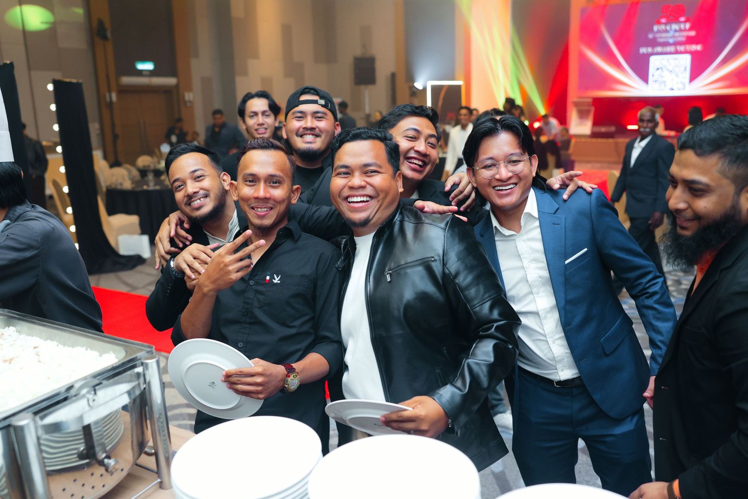 Group of happy men posing together smiling at a corporate gala dinner buffet event.