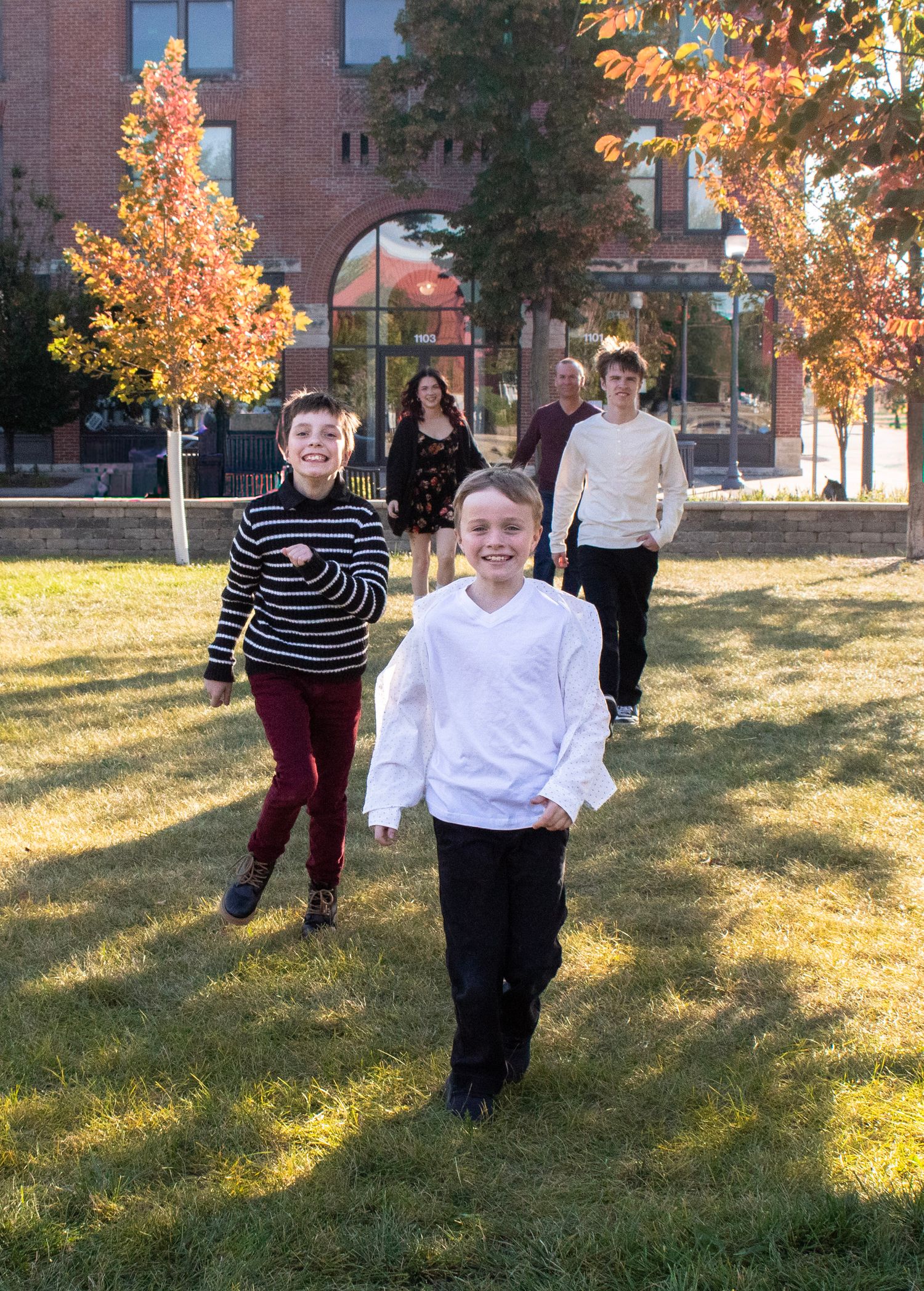 A sequence of five photos shows children running and playing on an autumn lawn with colorful fall trees in the background.