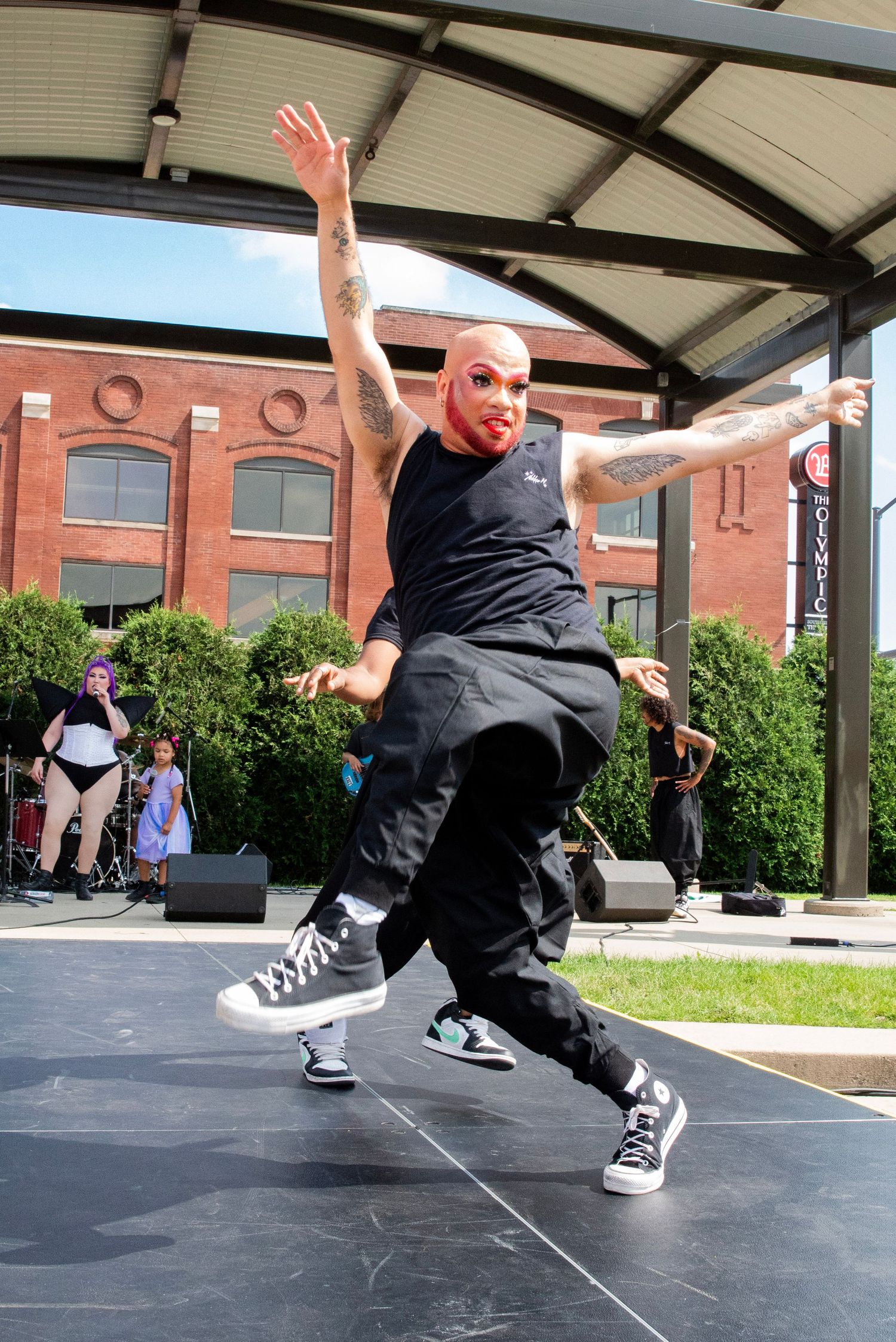 Dynamic dance moves captured in sequence under covered outdoor pavilion.