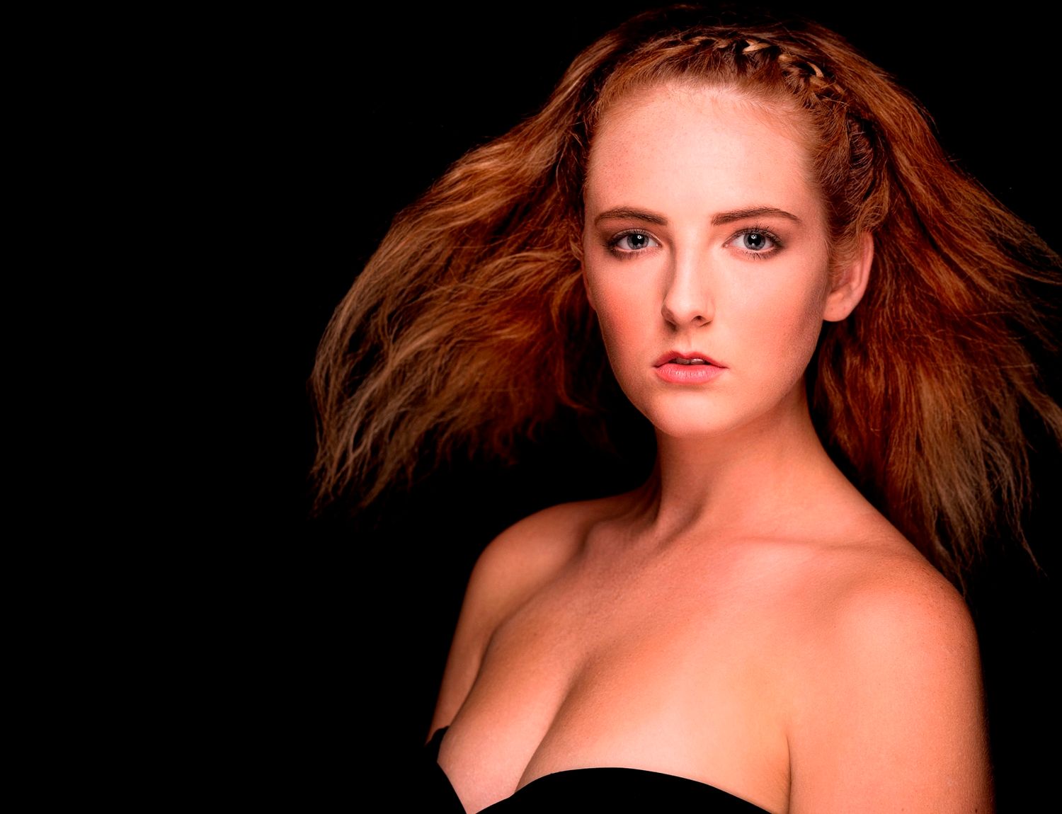Artistic beauty portrait with dramatic studio lighting against dark background.