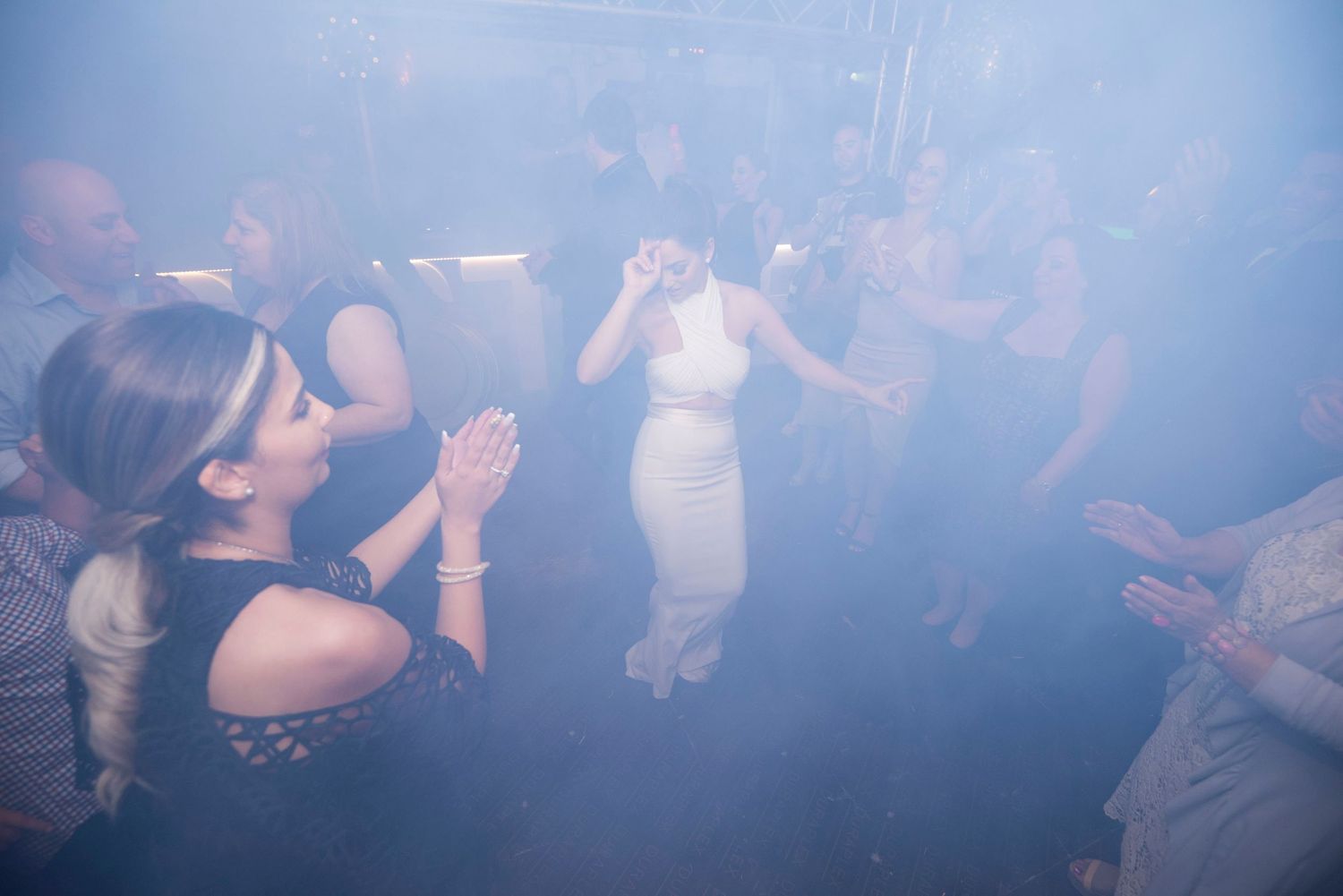 Corporate event photography Sydney. Hazy blue lighting illuminates a crowded dance floor at a nightclub event.