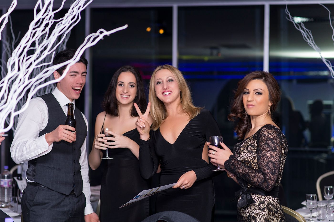 Corporate event photography Sydney. People in formal attire gathered at an elegant corporate event with black and white decor.