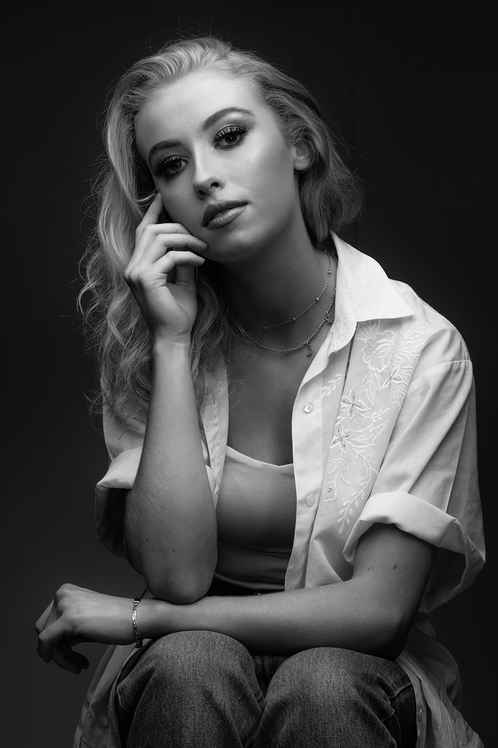 Black and white portrait series showing dramatic poses against dark background.