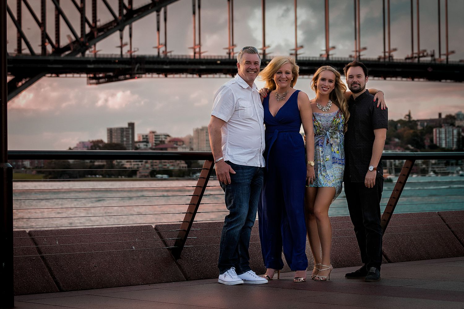 Group gathering at sunset near Sydney Harbour Bridge for photos.
