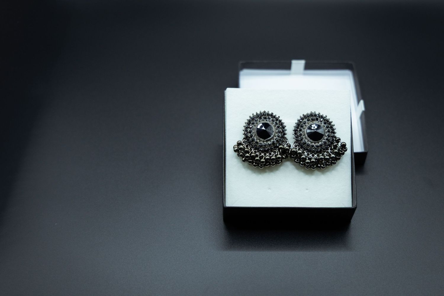 Product photography Sydney. Black jewellery arranged in a progressive sequence showing different styles and lengths on white backgrounds.