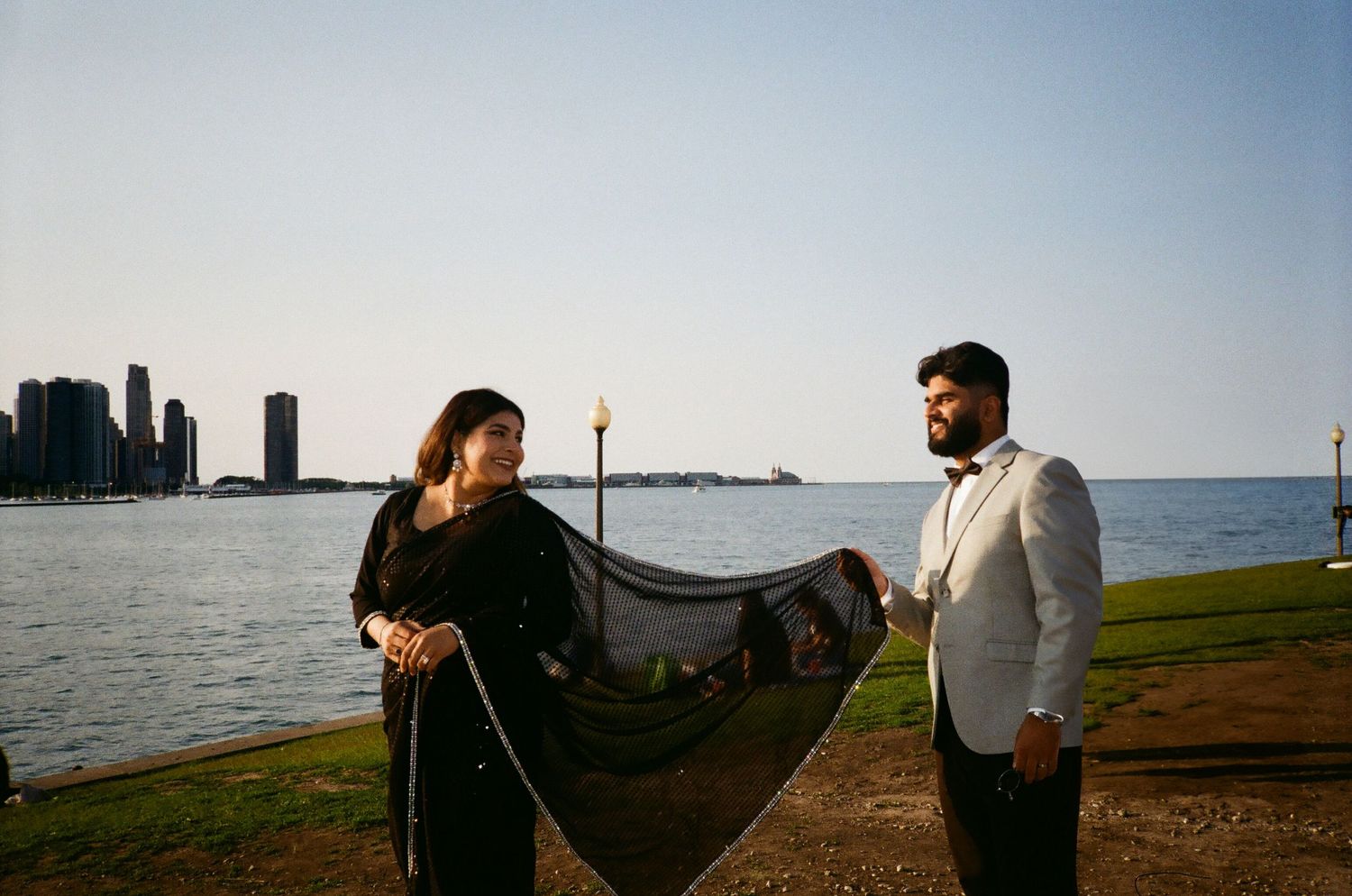 Bollywood-style picture moment by Lake Michigan: Chicago skyline 35mm film light. adler planetarium venue wedding