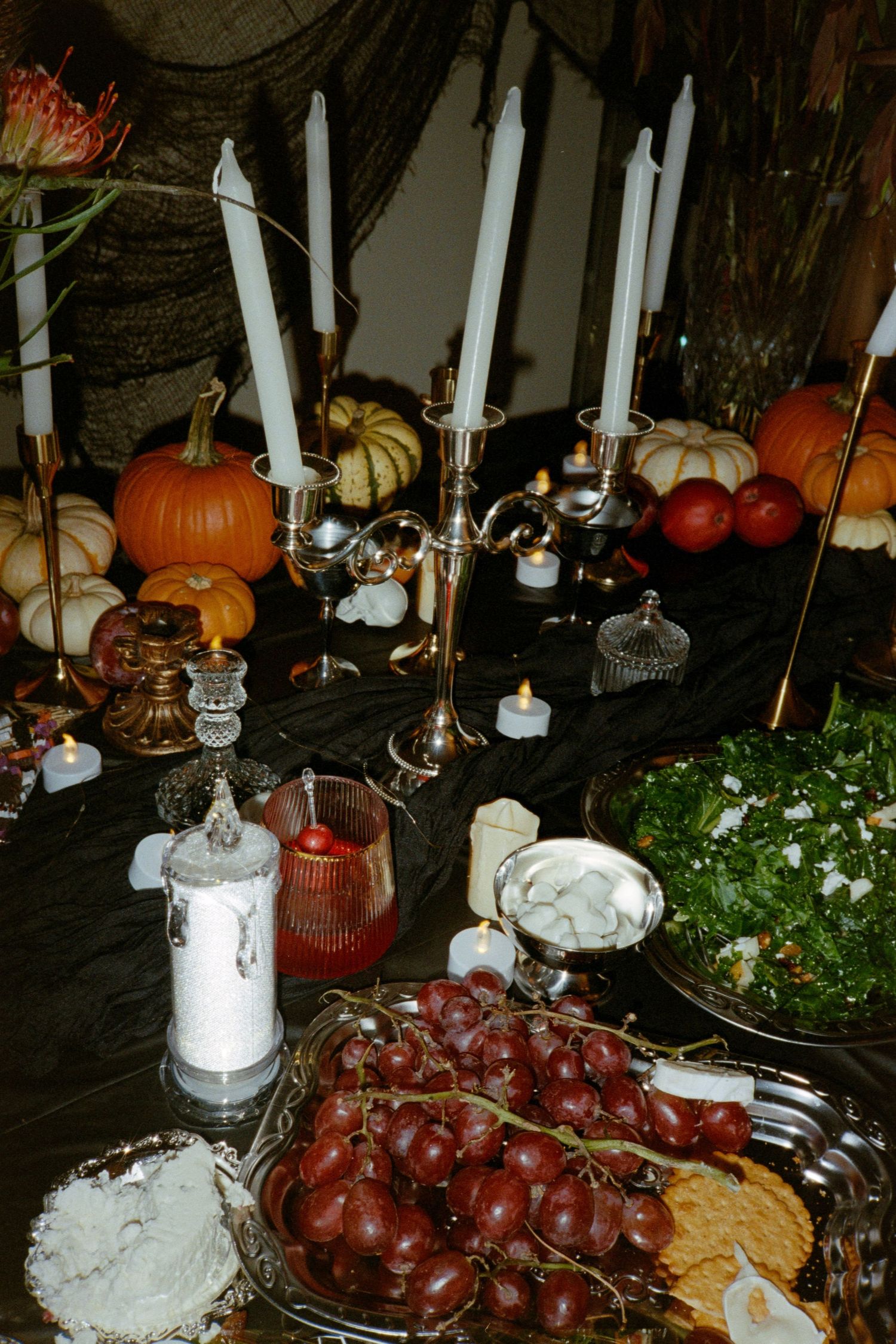 Moody, sultry Halloween party decor in Chicago suburbs with dark academia vibes—captured on vintage 35mm film for timeless atmosphere.